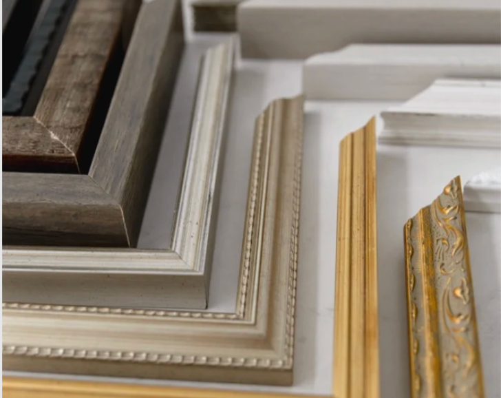 Collection of decorative picture frames in gold, white, and gray tones displayed together for home decor framing options.