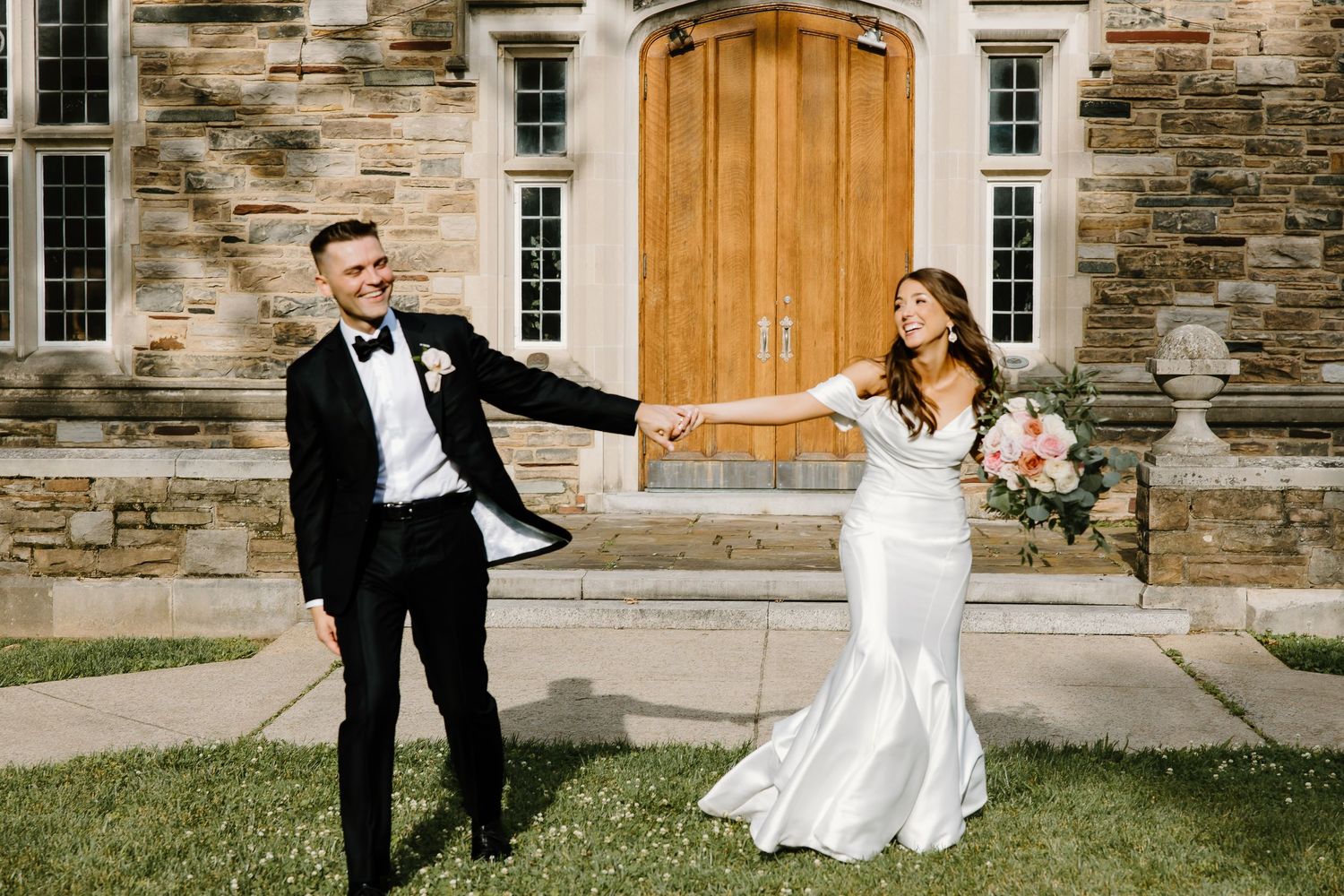 Wedding portraits taken against stone building with wooden doors.