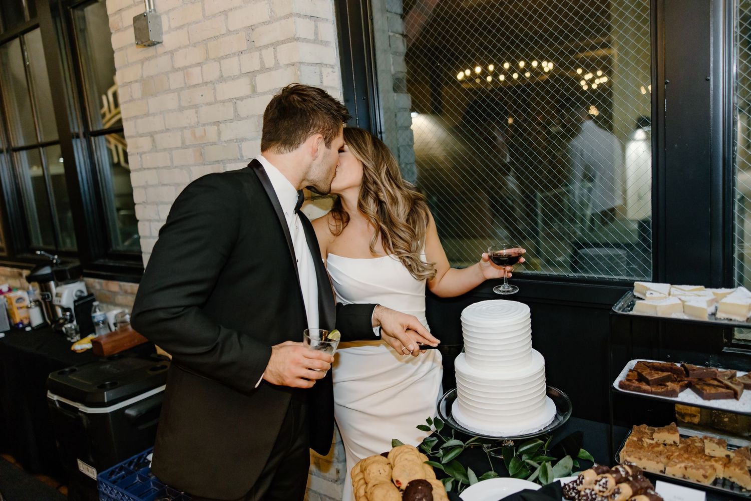 Wedding couple sharing a moment while cutting their traditional white cake.