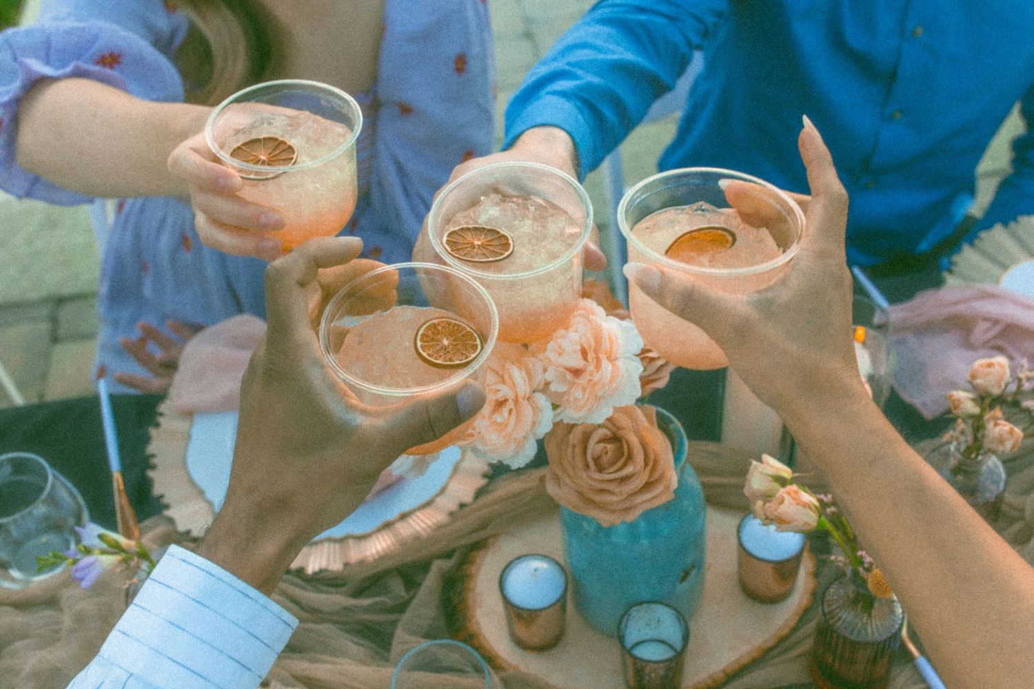 Wedding guests toasting with champagne glasses at an outdoor celebration.