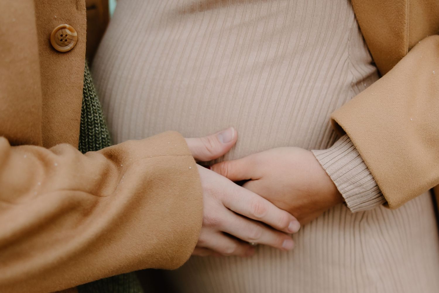 Close-up maternity photos showing gentle hands cradling baby bump.