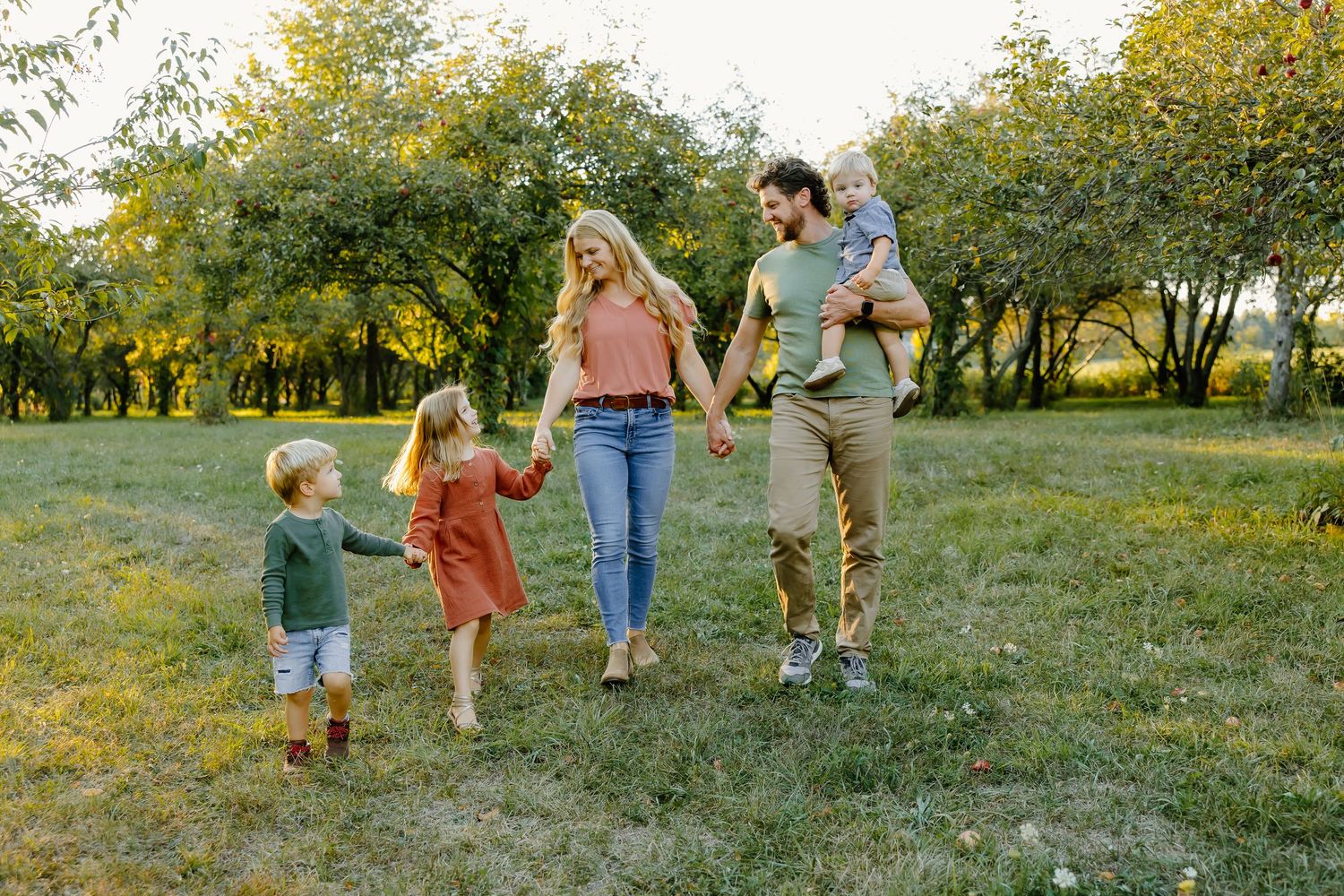 Family members walking together through a scenic park during golden hour.