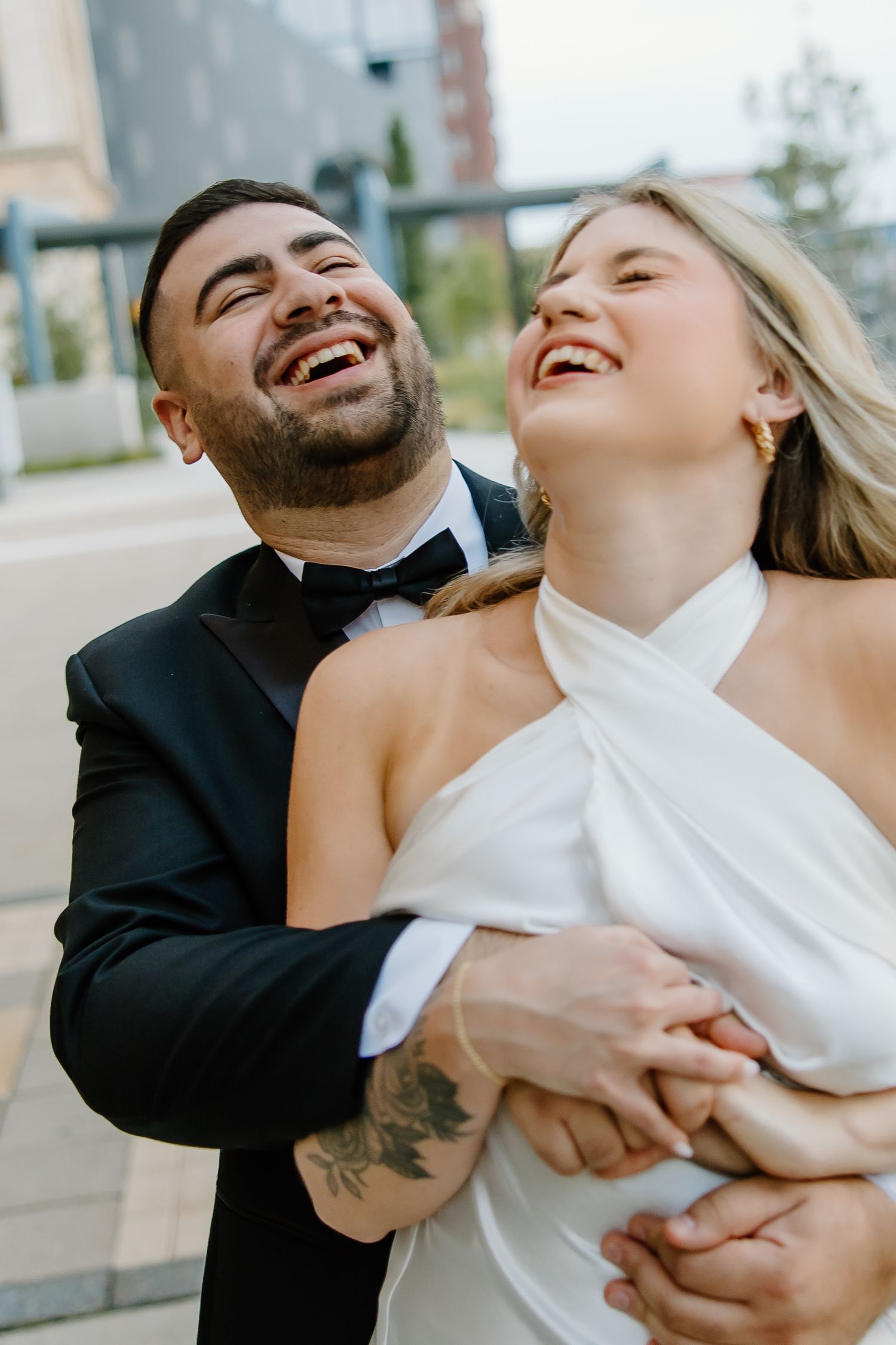Couple laughing together during an intimate moment in formal attire.