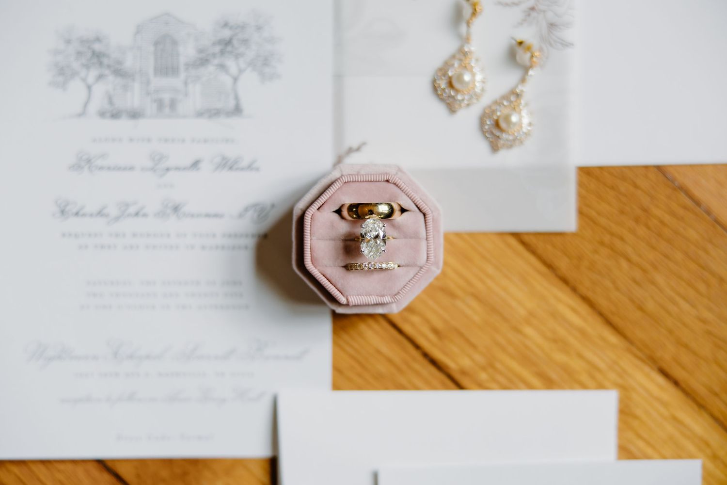 Elegant wedding invitations and stationery laid out on wooden surface with delicate details.