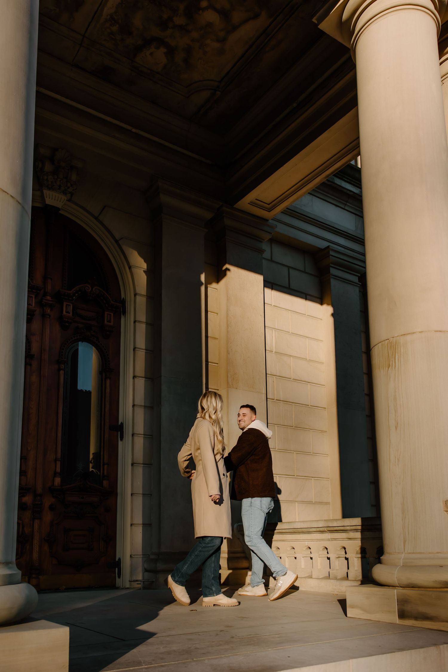 Architectural photo showing dramatic shadows and columns with figures in the distance.