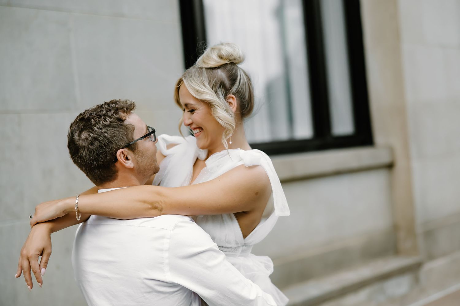 Romantic embrace against stone building exterior.