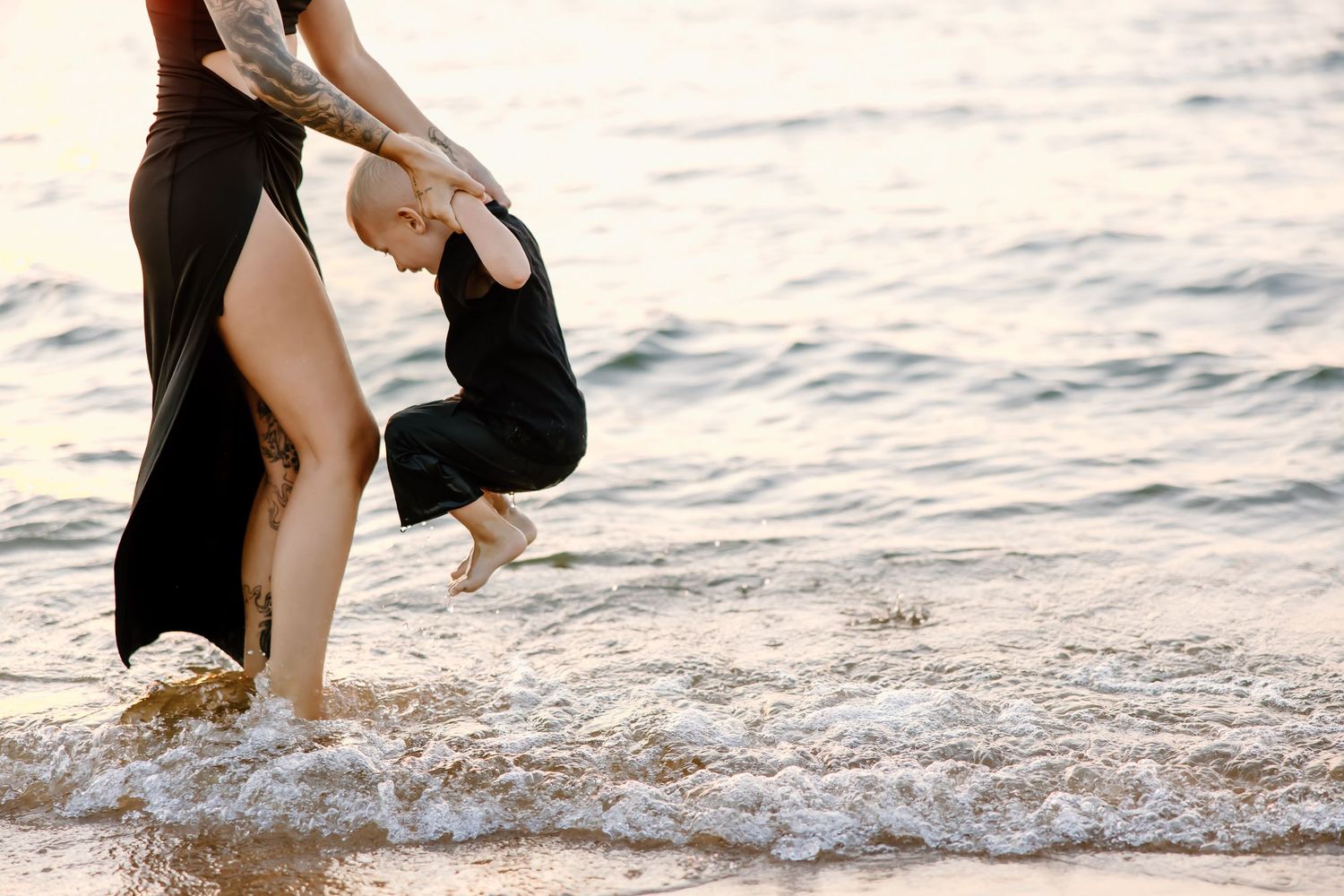 Playful moments captured at the shoreline as waves roll in during sunset.