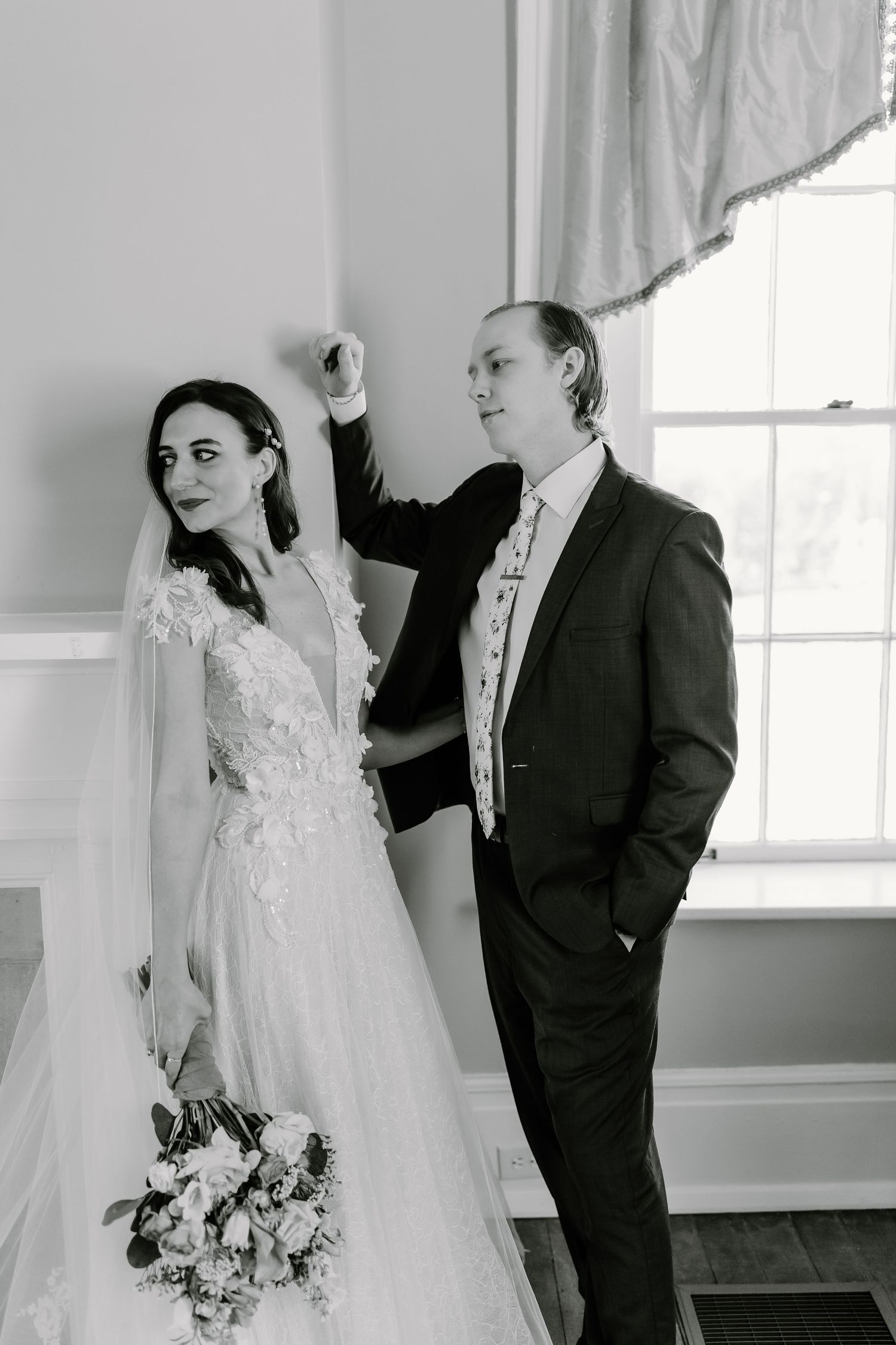 Intimate black and white wedding portraits showing tender moments between a couple in a sunlit room.