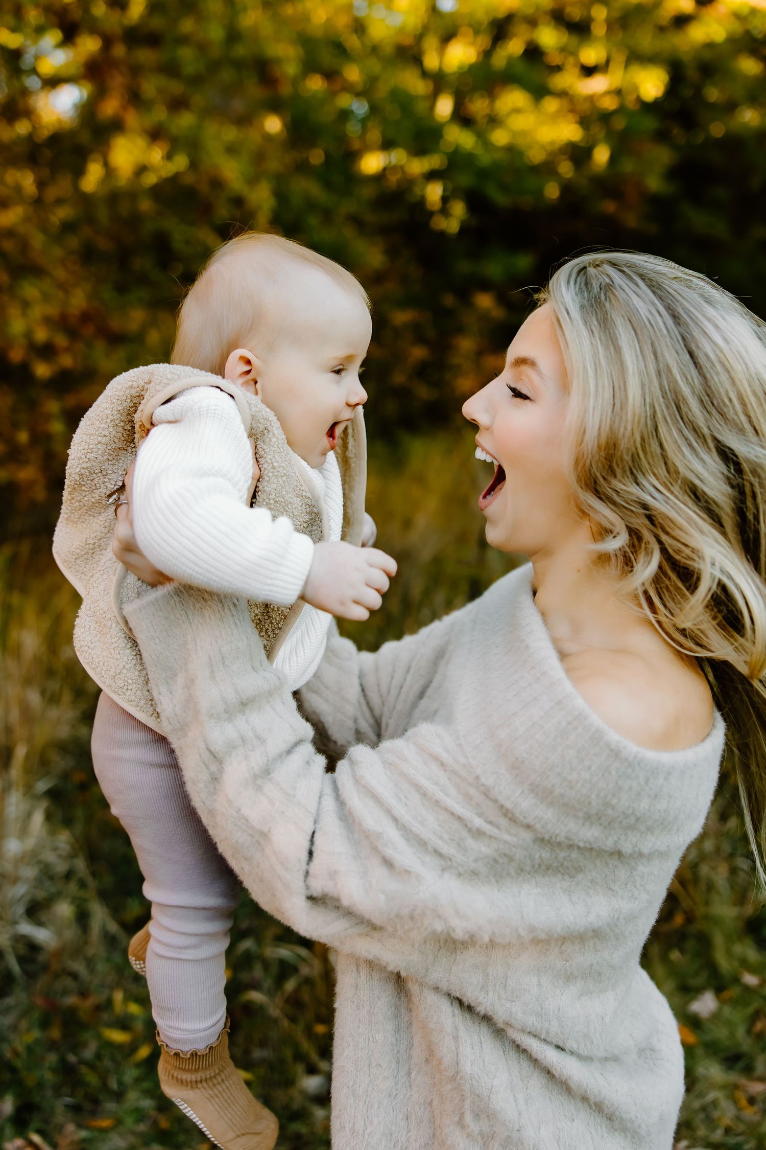 Playful interaction between parent and child against golden autumn backdrop.