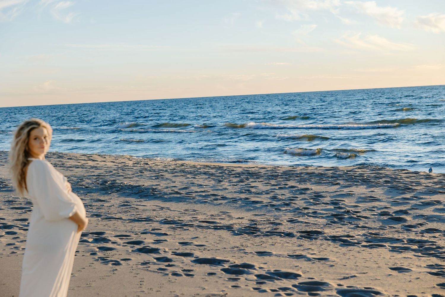 Serene beachside photography with waves and sandy shoreline at sunset.