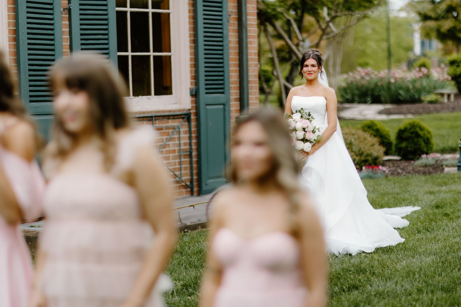 Wedding party scene with bridesmaids in pink dresses and bride in white gown.