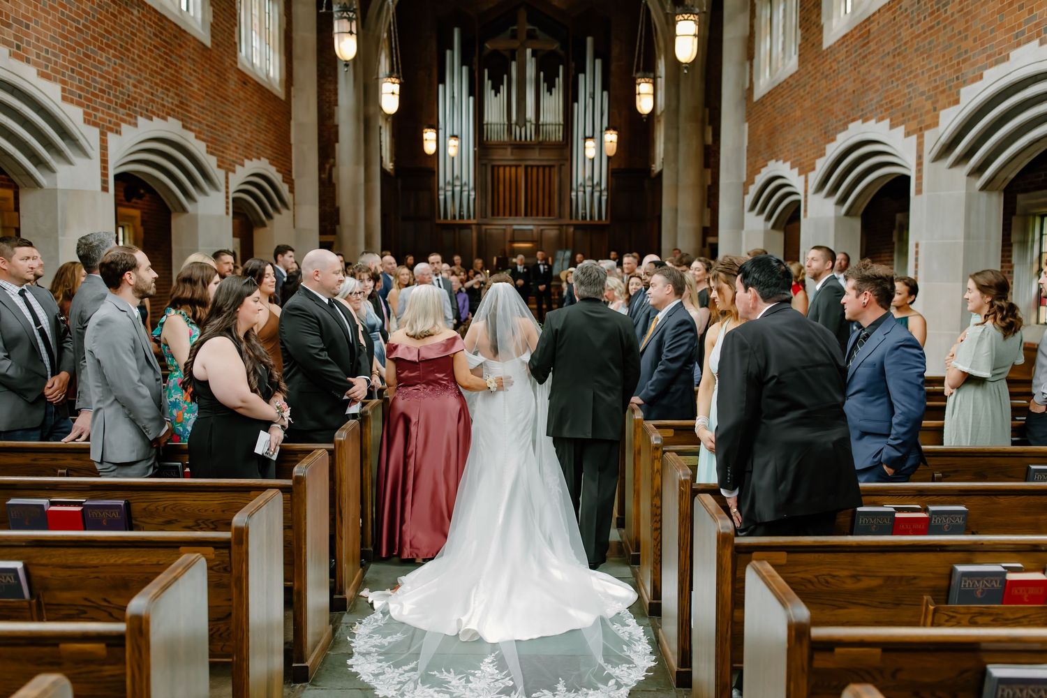 Wedding ceremony in a traditional church with wooden pews and gothic architecture.