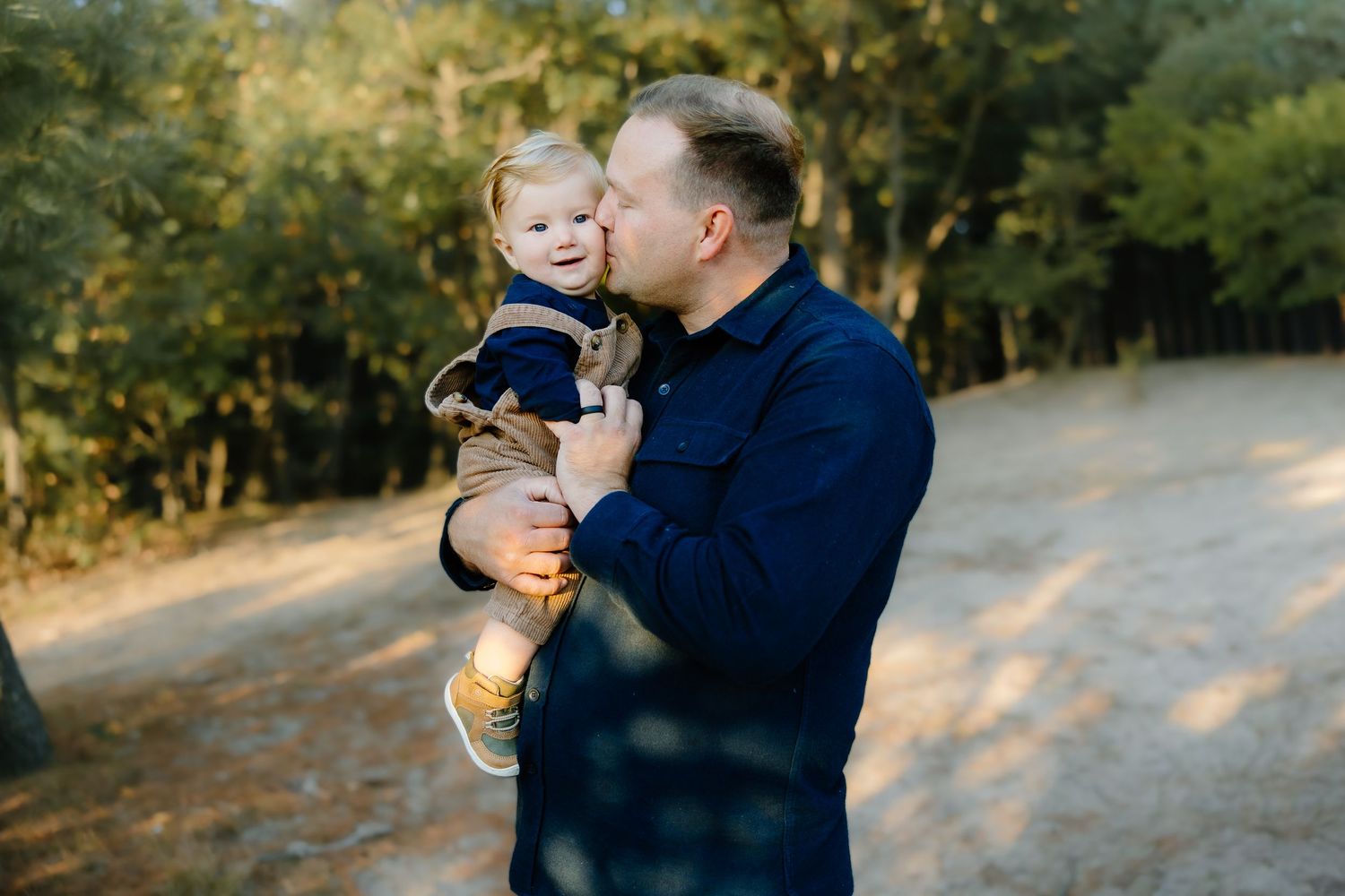 Loving family interaction during sunset photoshoot among autumn trees.