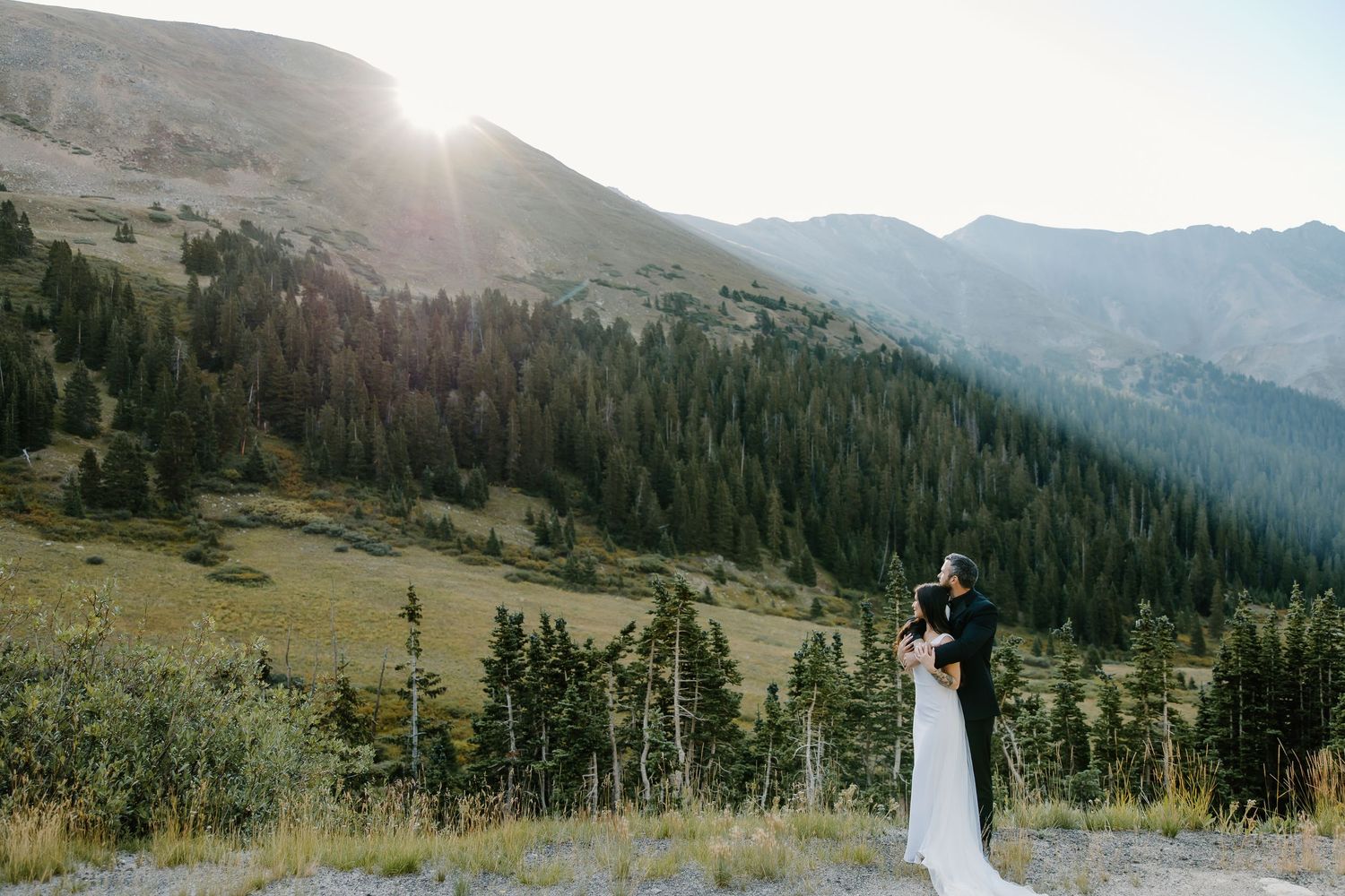 Scenic mountain vista with evergreen forest and sunlit peaks during a wedding ceremony.