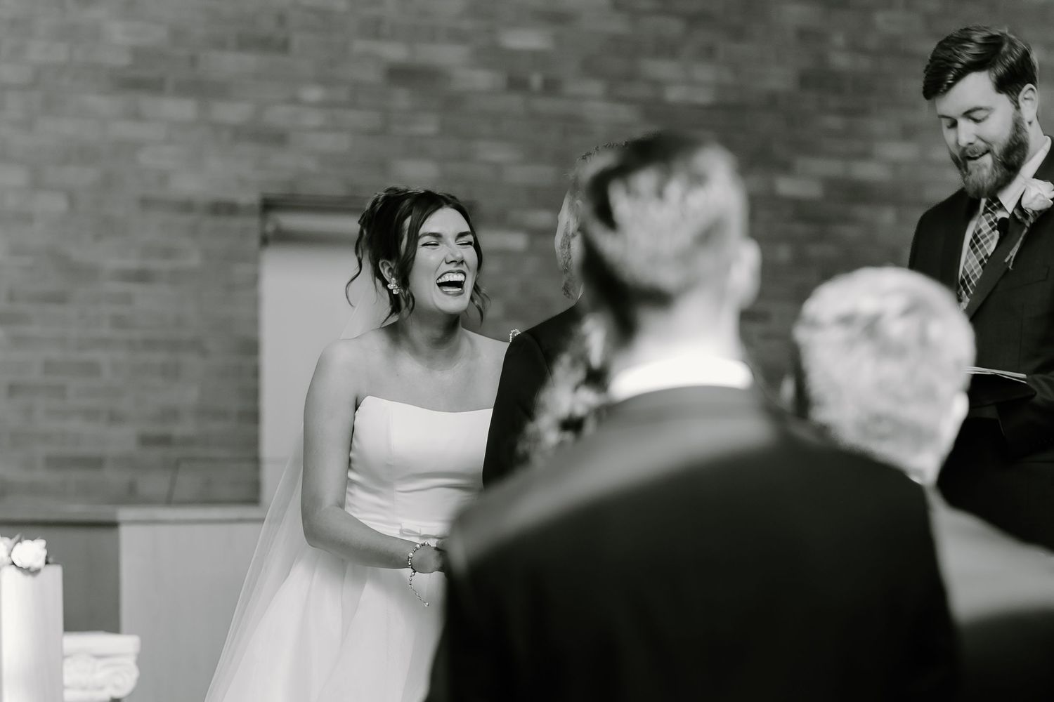 An emotional moment captured during a wedding ceremony in a brick-walled church.