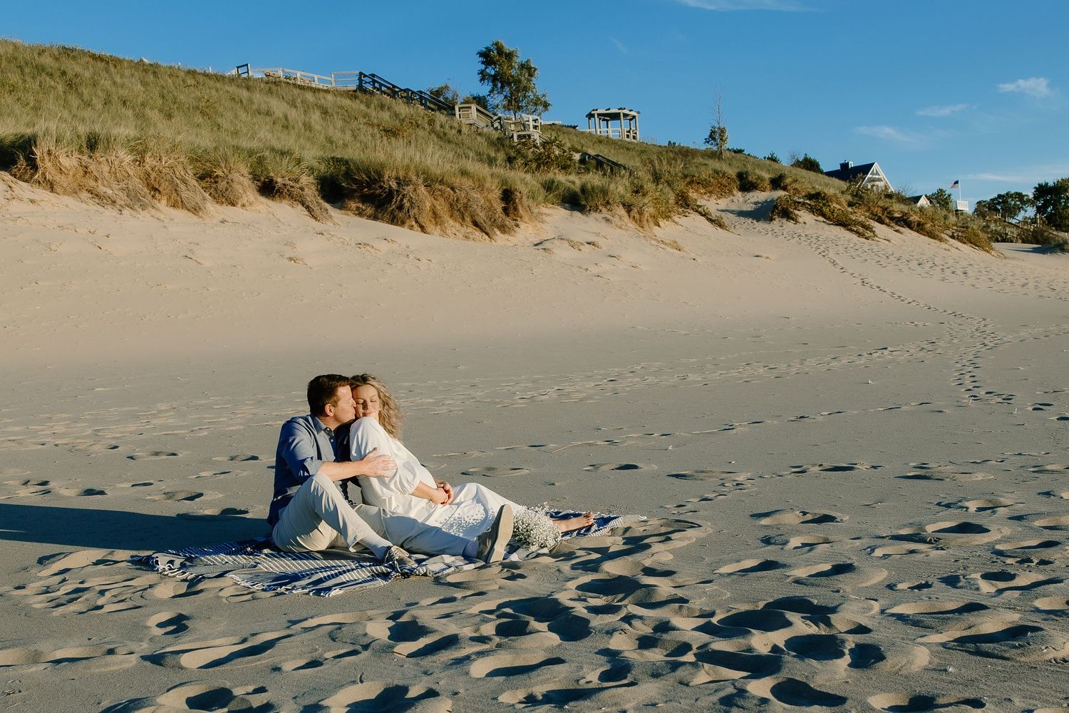 Scenic beach landscape with sand dunes and couple enjoying a romantic moment.