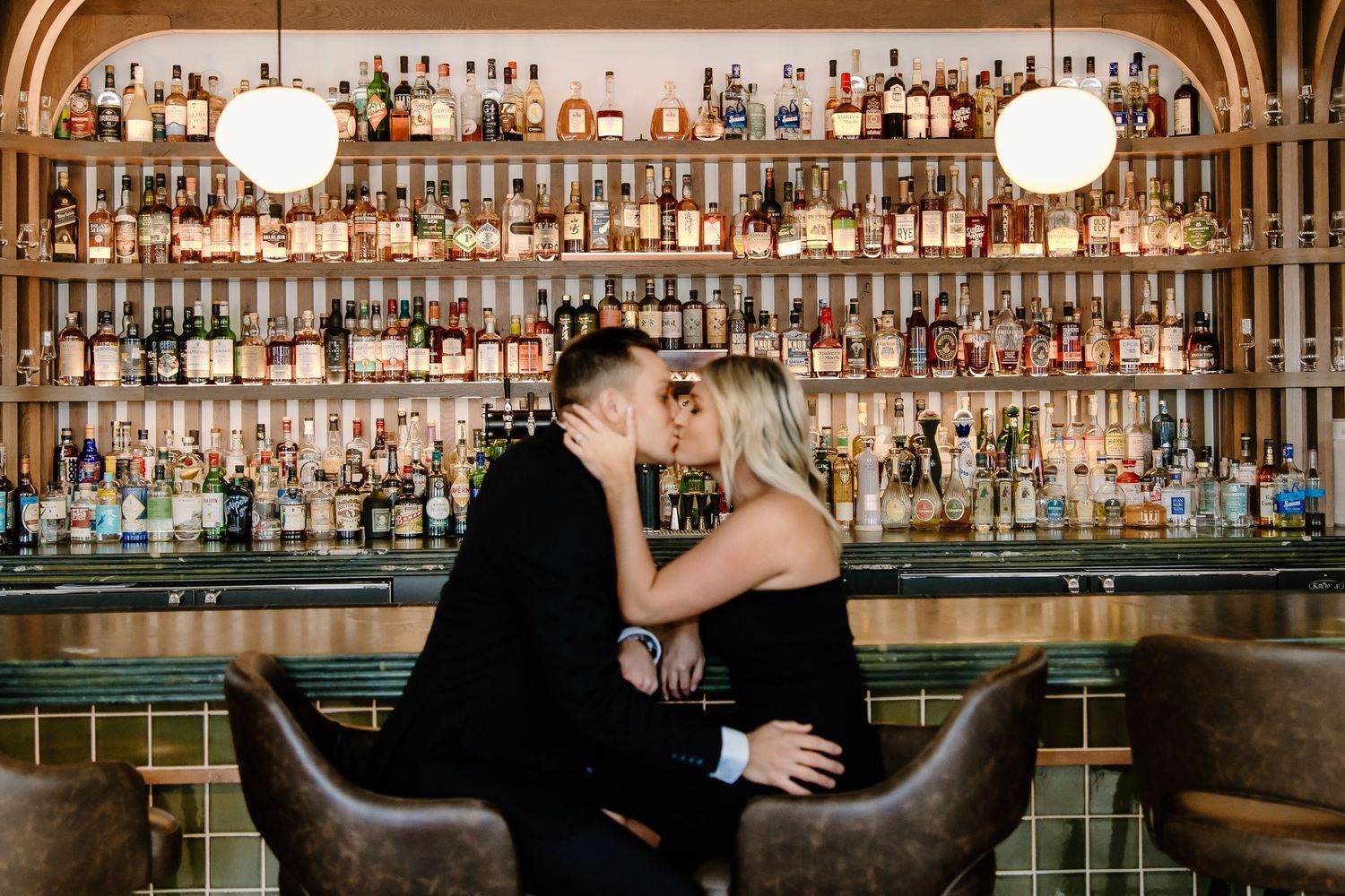 Elegant bar interior with arched shelving displaying extensive liquor collection.