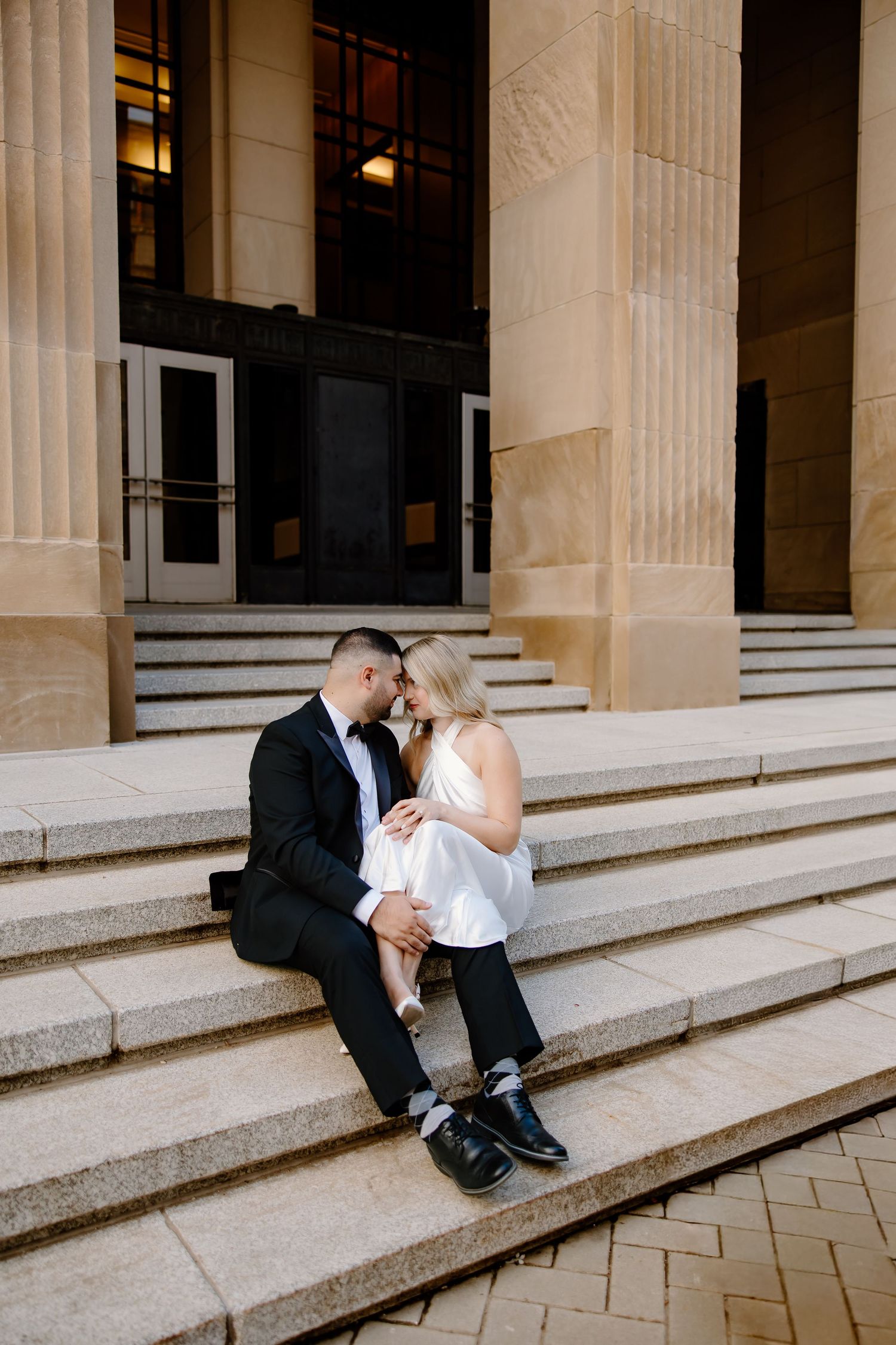 Classic wedding photos captured against columned building architecture.