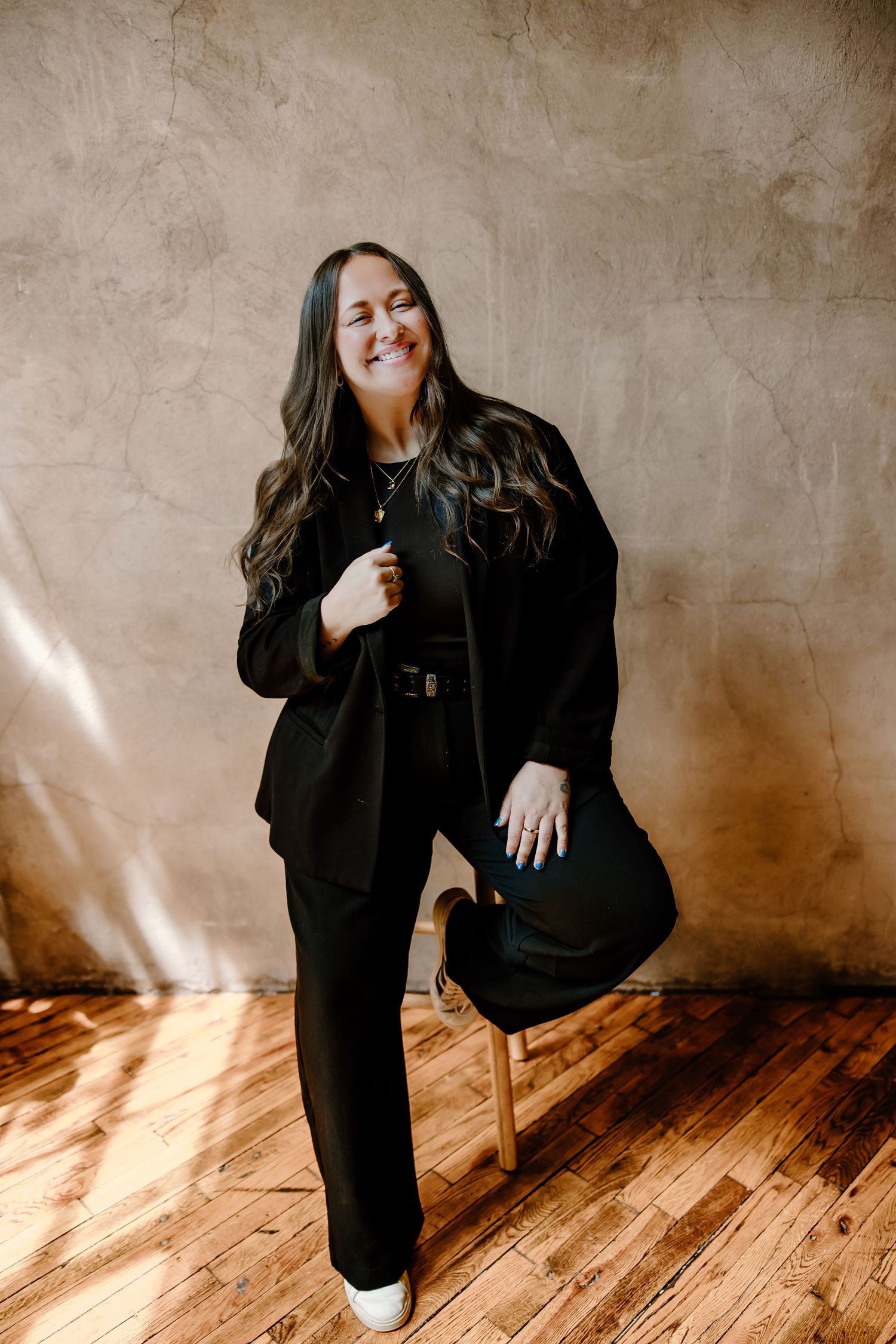 Artistic photo series showing a person in black attire posing expressively against a textured wall on wooden flooring.