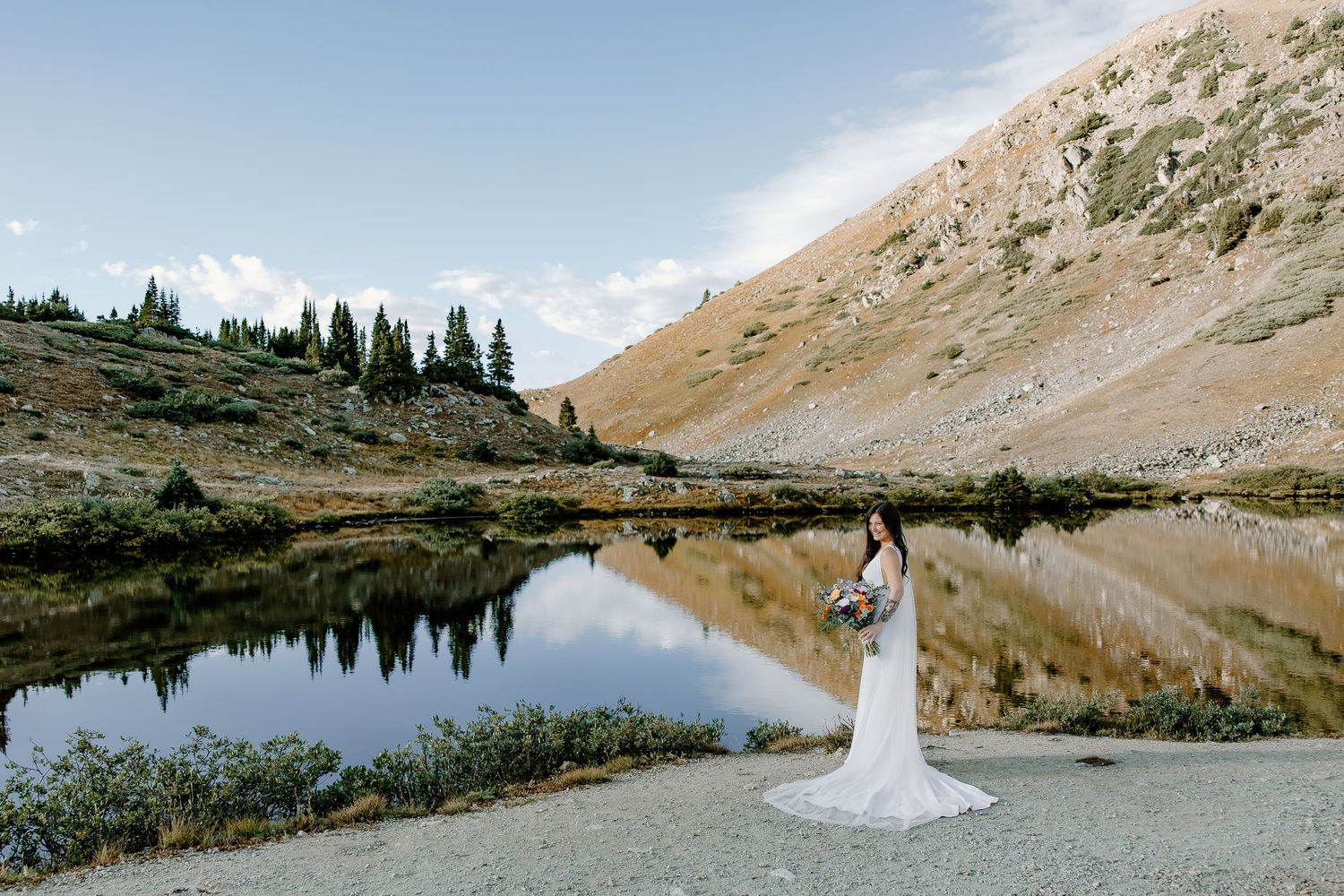 Scenic mountain wedding photography with alpine lake and rugged peaks.
