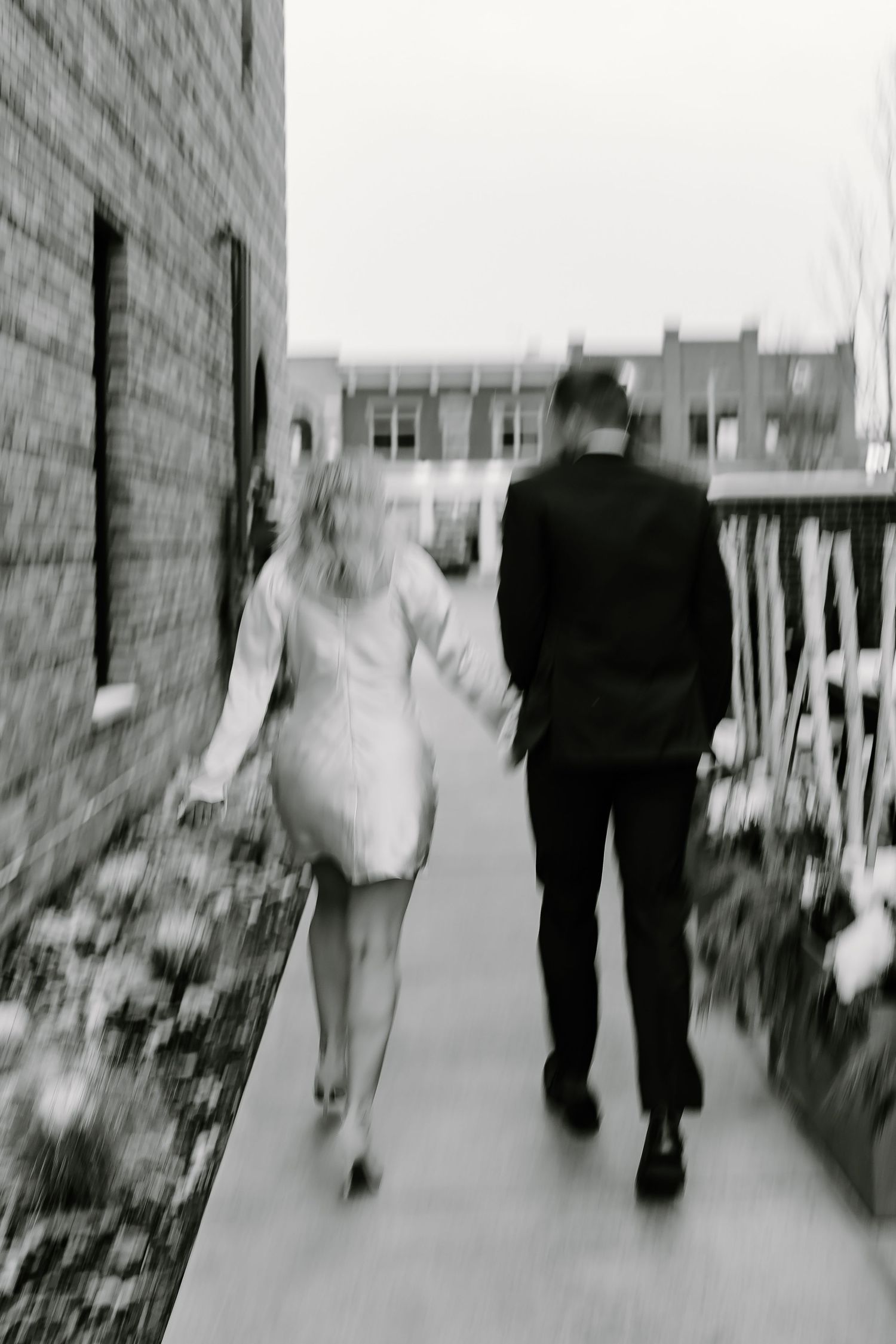 Black and white photo of a couple walking down a path together.