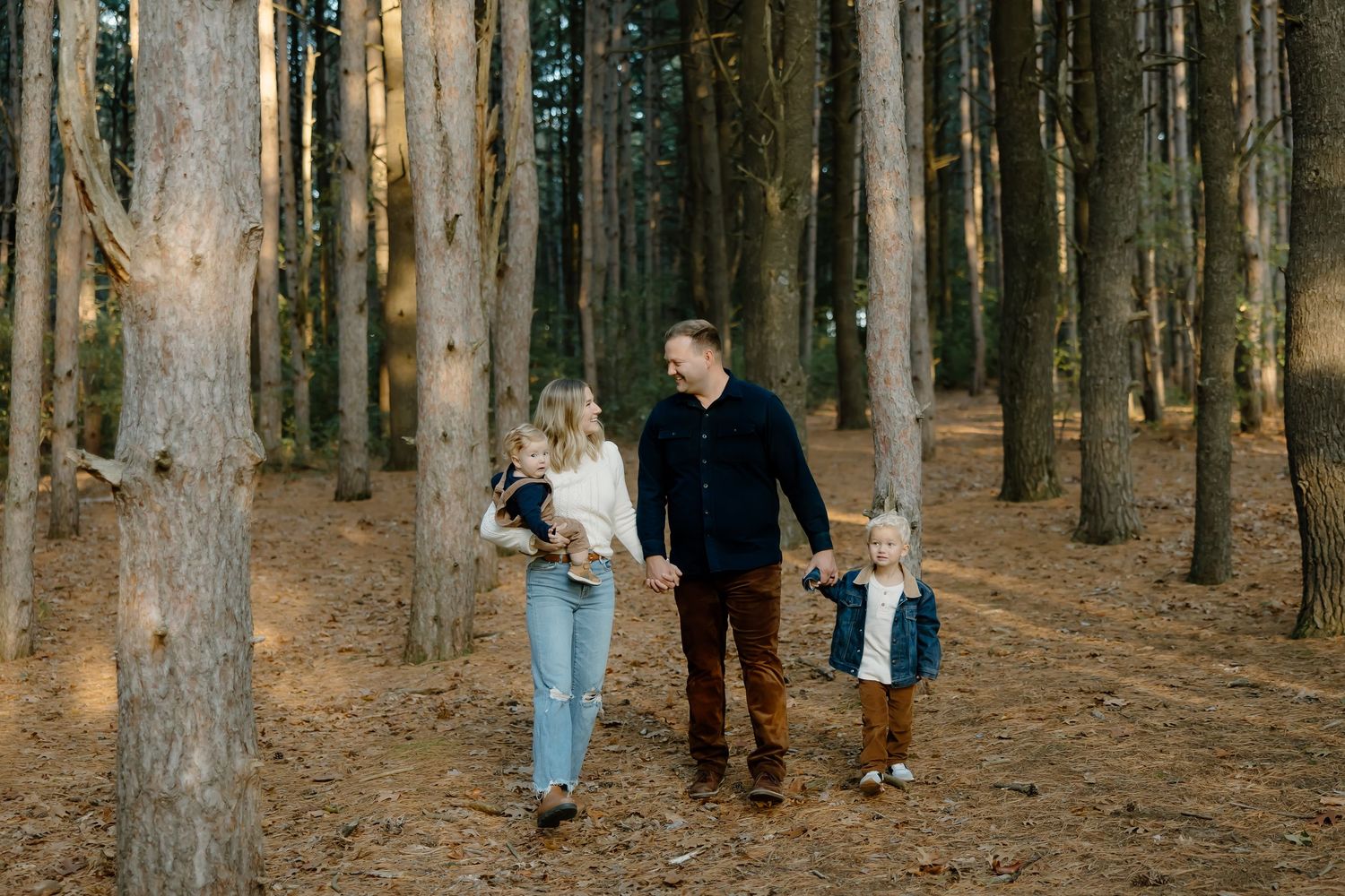 Family walking together through wooded forest path.
