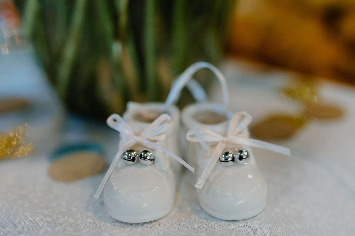 Small white baby shoes arranged in a row showing different angles and details of the delicate footwear.