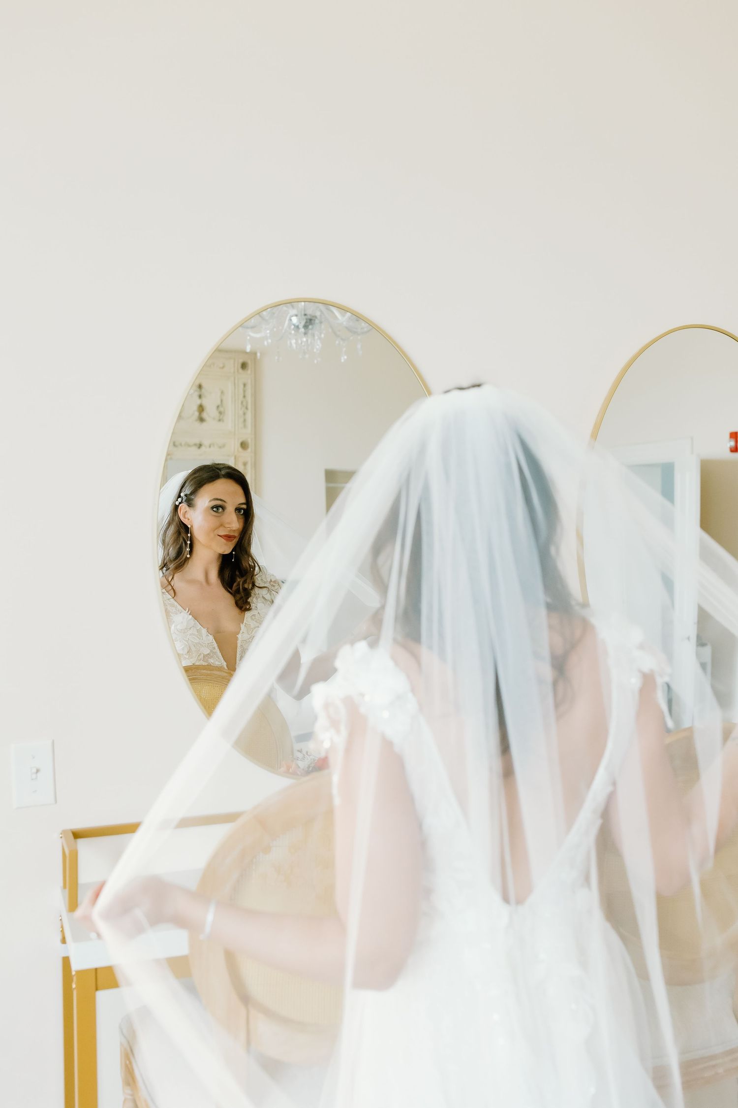 Ethereal bridal portraits through mirrors with flowing white veil creating dreamy reflections.