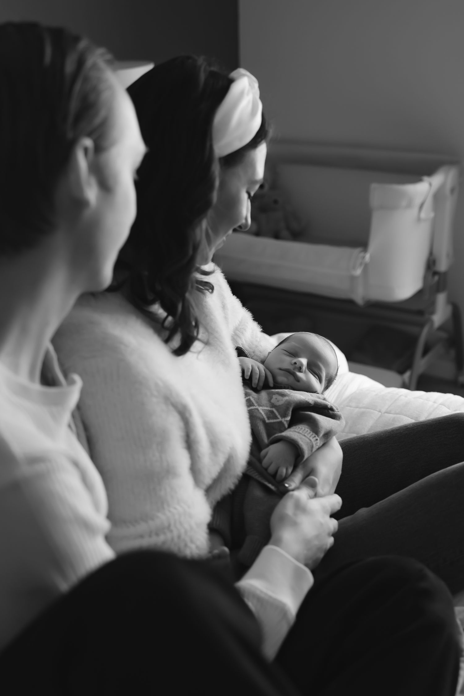 A series of intimate black and white photos showing tender moments between parent and newborn.