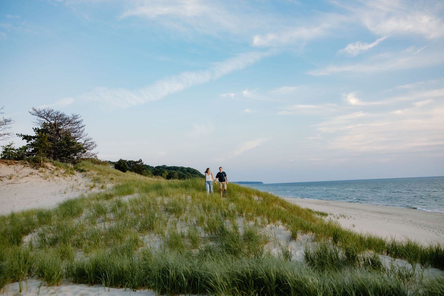 Scenic shoreline view with sand dunes and beach grass along Lake Michigan.