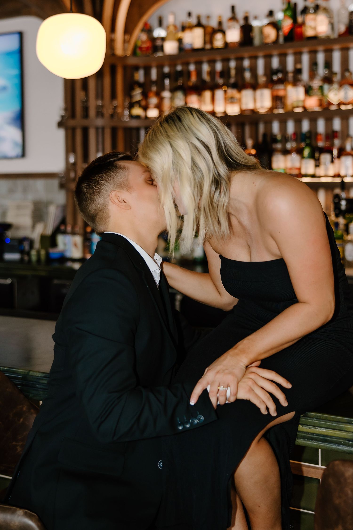 Romantic couple sharing intimate moments at an elegant bar setting.