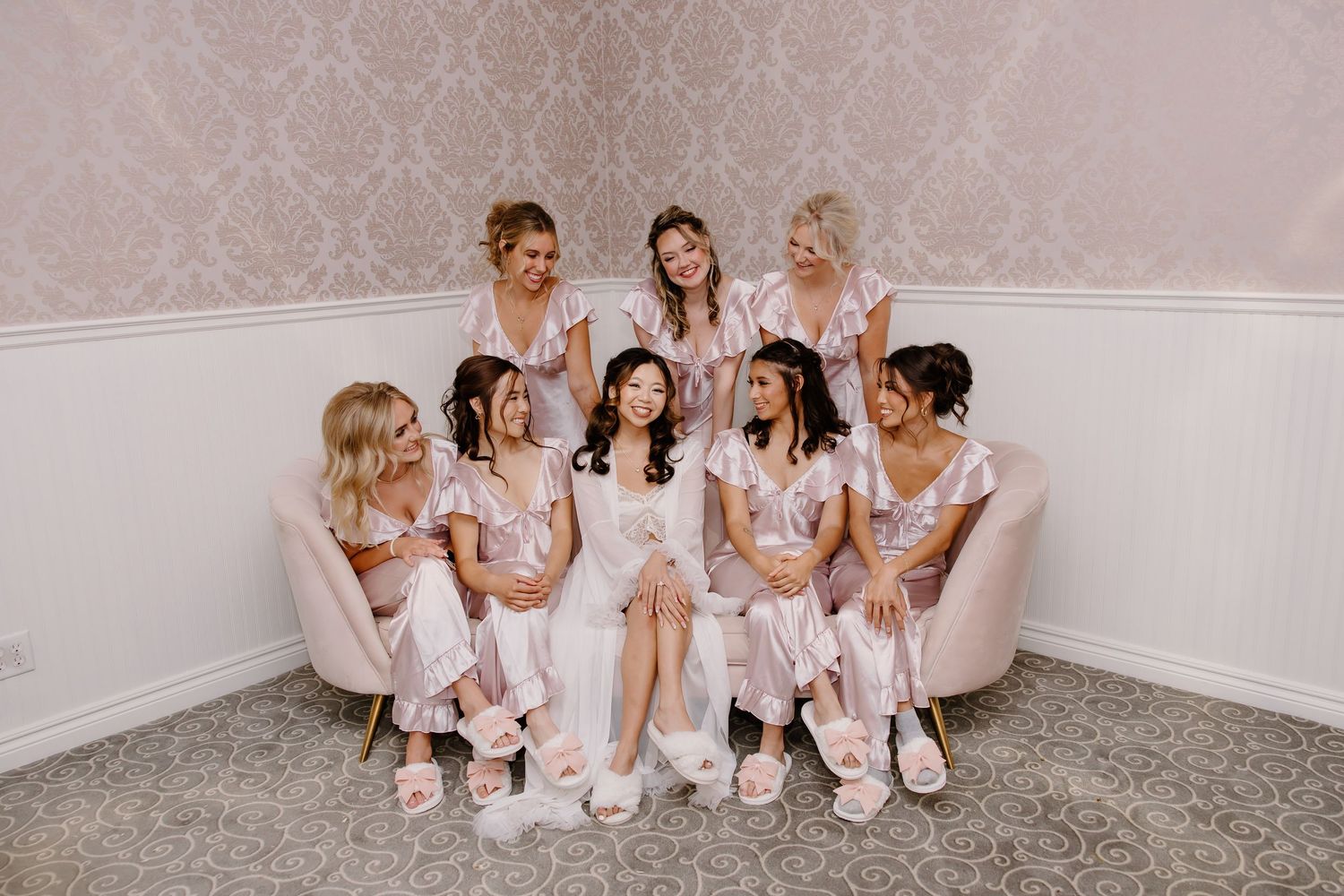 Wedding party members relax in matching robes during pre-ceremony preparations.