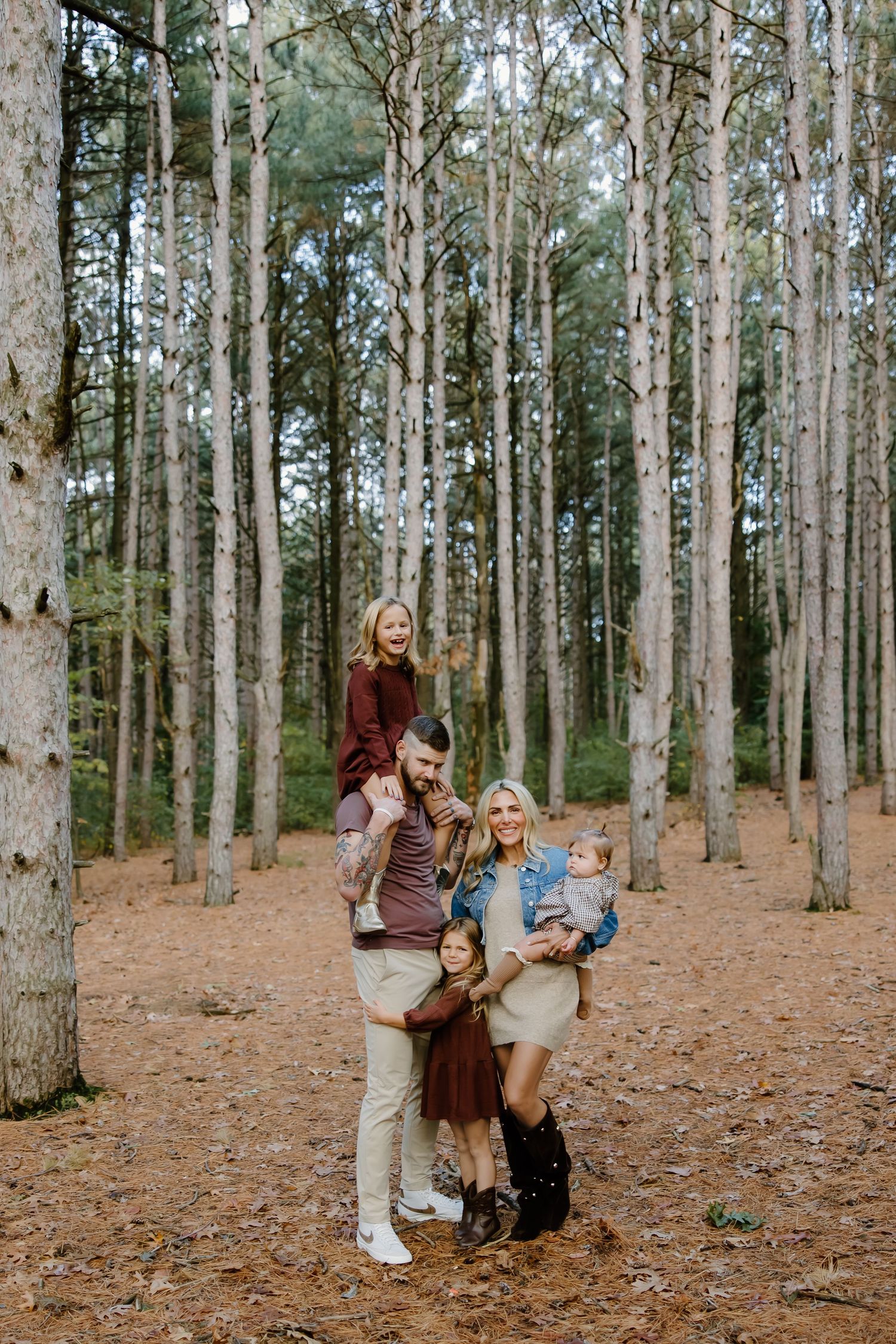 Candid moments captured of a family enjoying time together among tall pine trees.