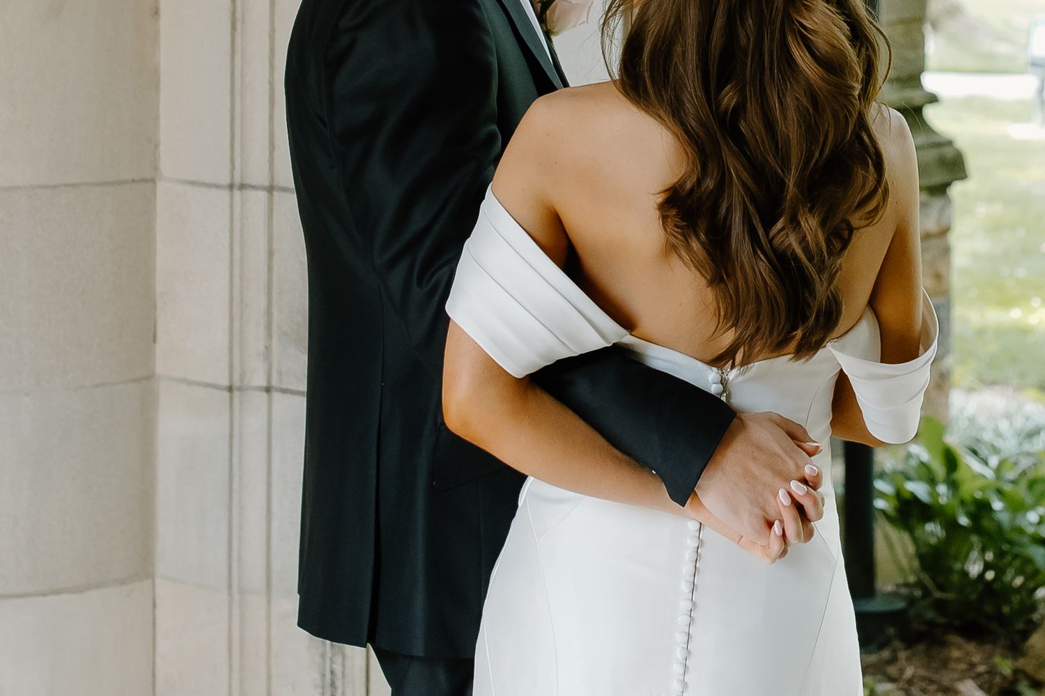 Romantic outdoor wedding portraits captured against stone architecture with natural lighting.