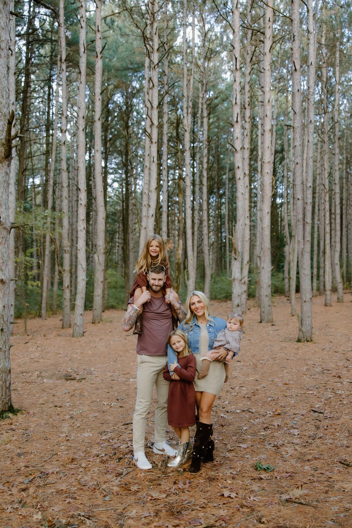 Family members walking and playing together in a serene pine forest.