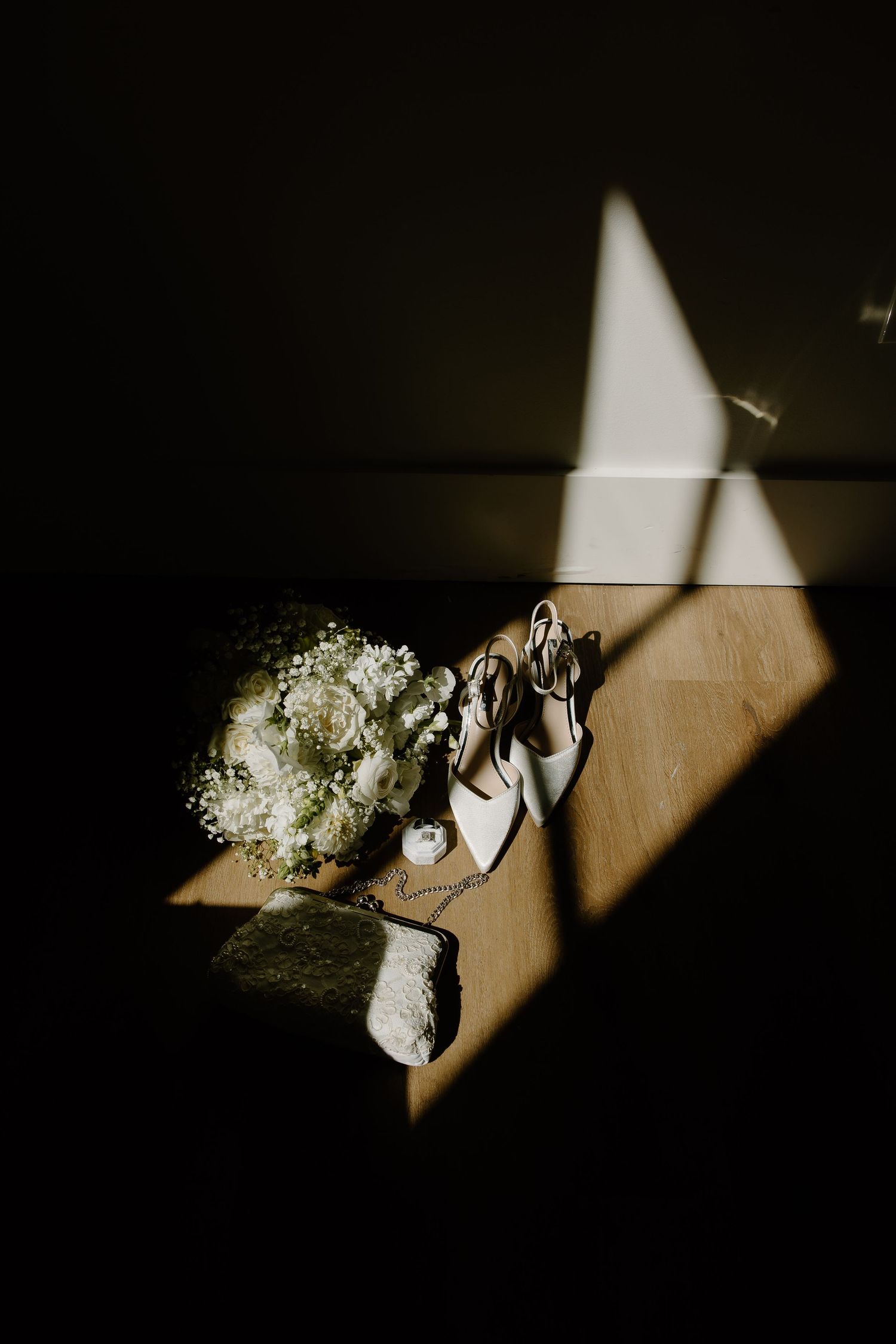 Dramatic shadows fall across wedding accessories and flowers.