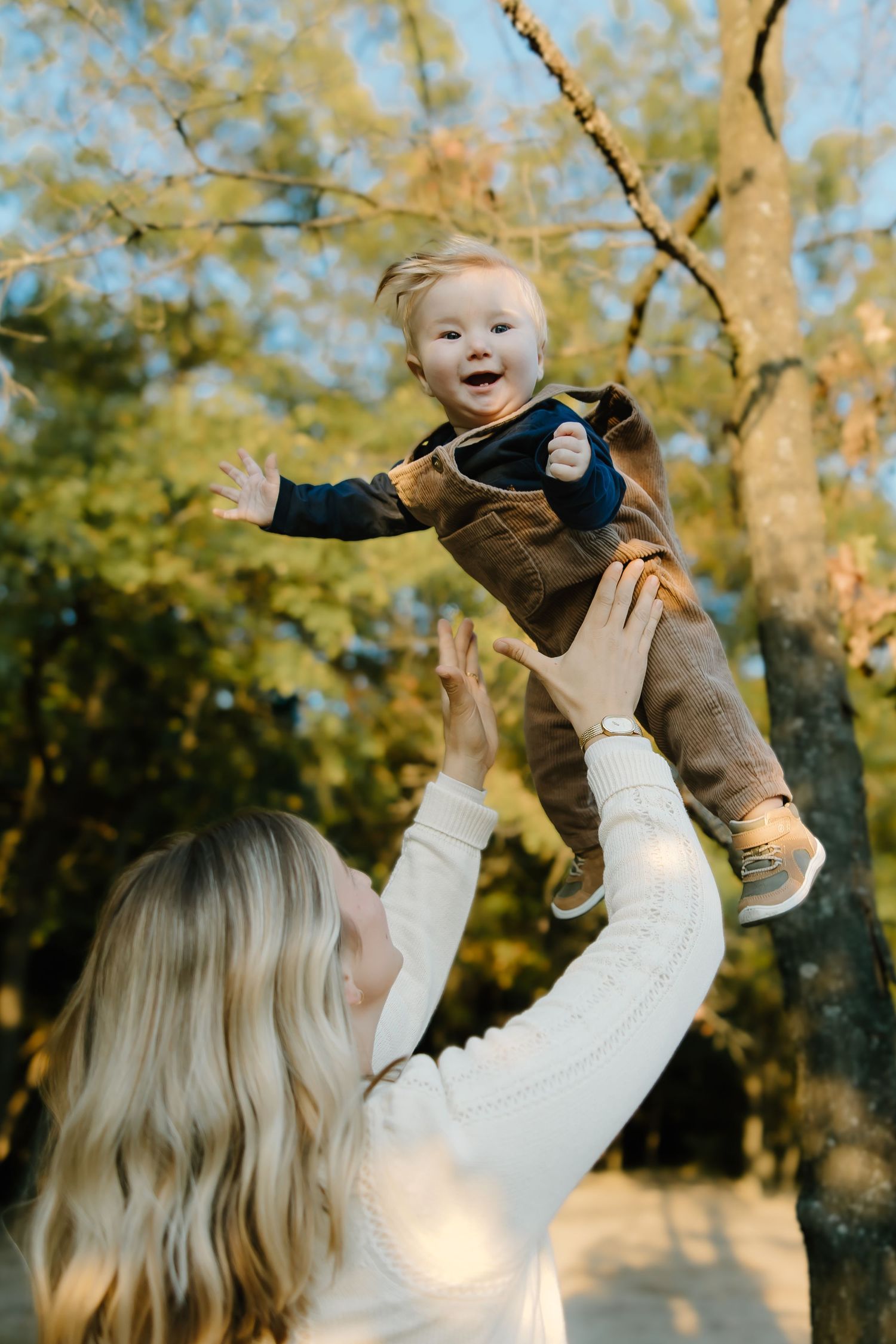 Joyful playtime captured during outdoor family photo session in autumn.