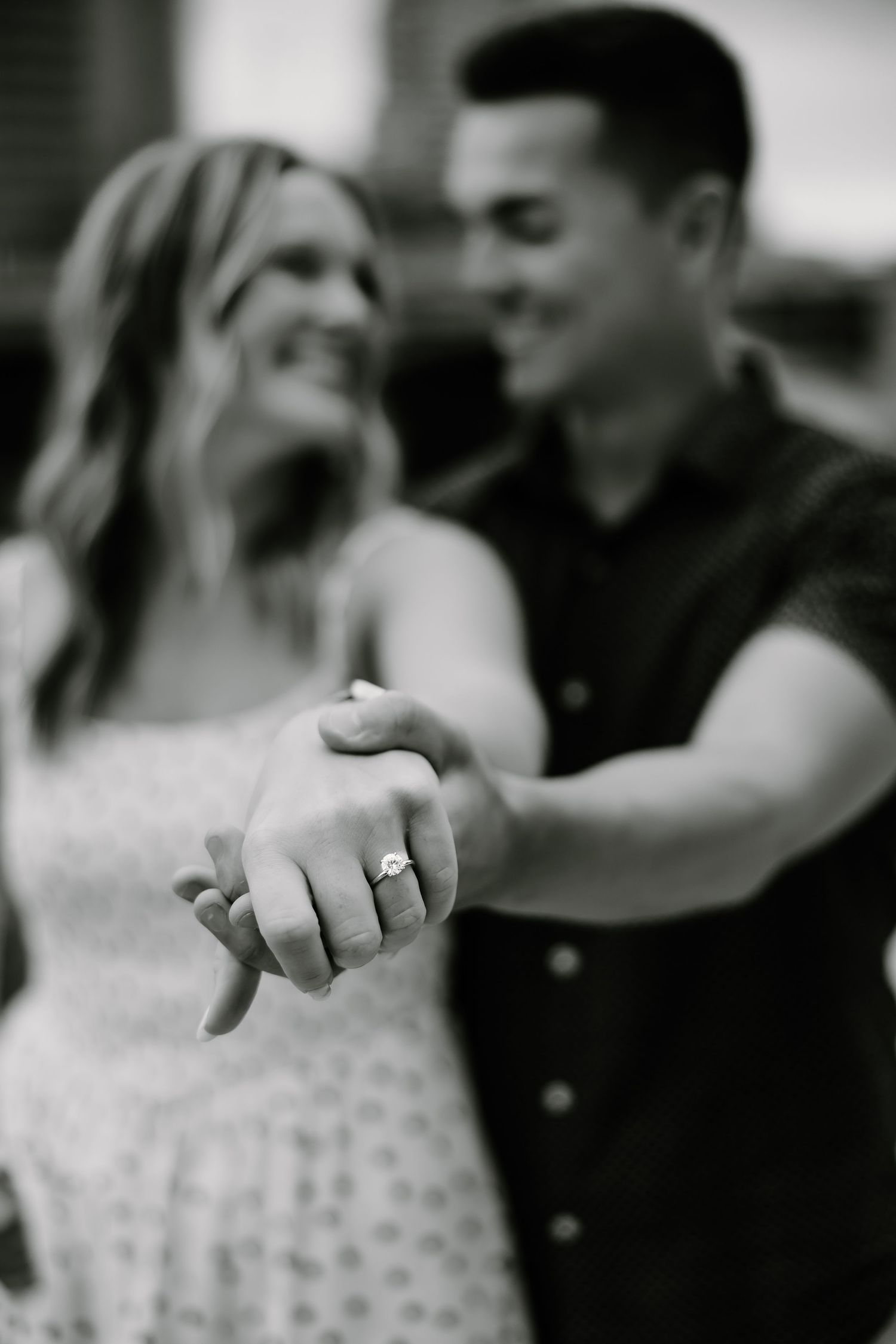 Black and white engagement photos showing close-up details of ring and embracing couple.