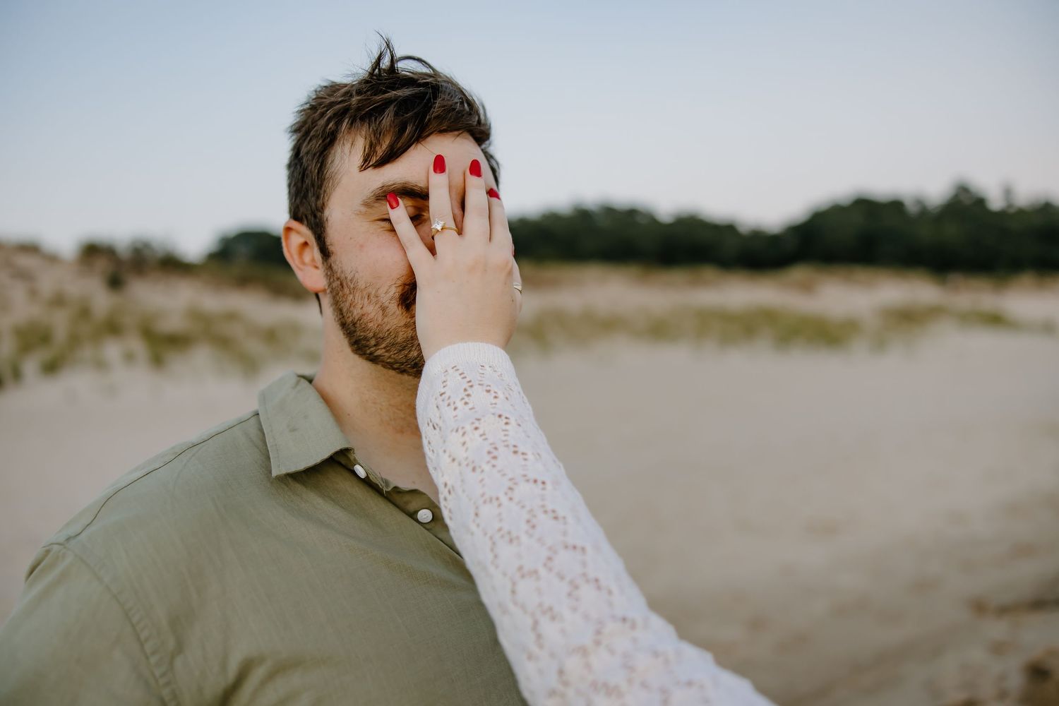 A romantic couple shares tender moments during a beach sunset photoshoot.