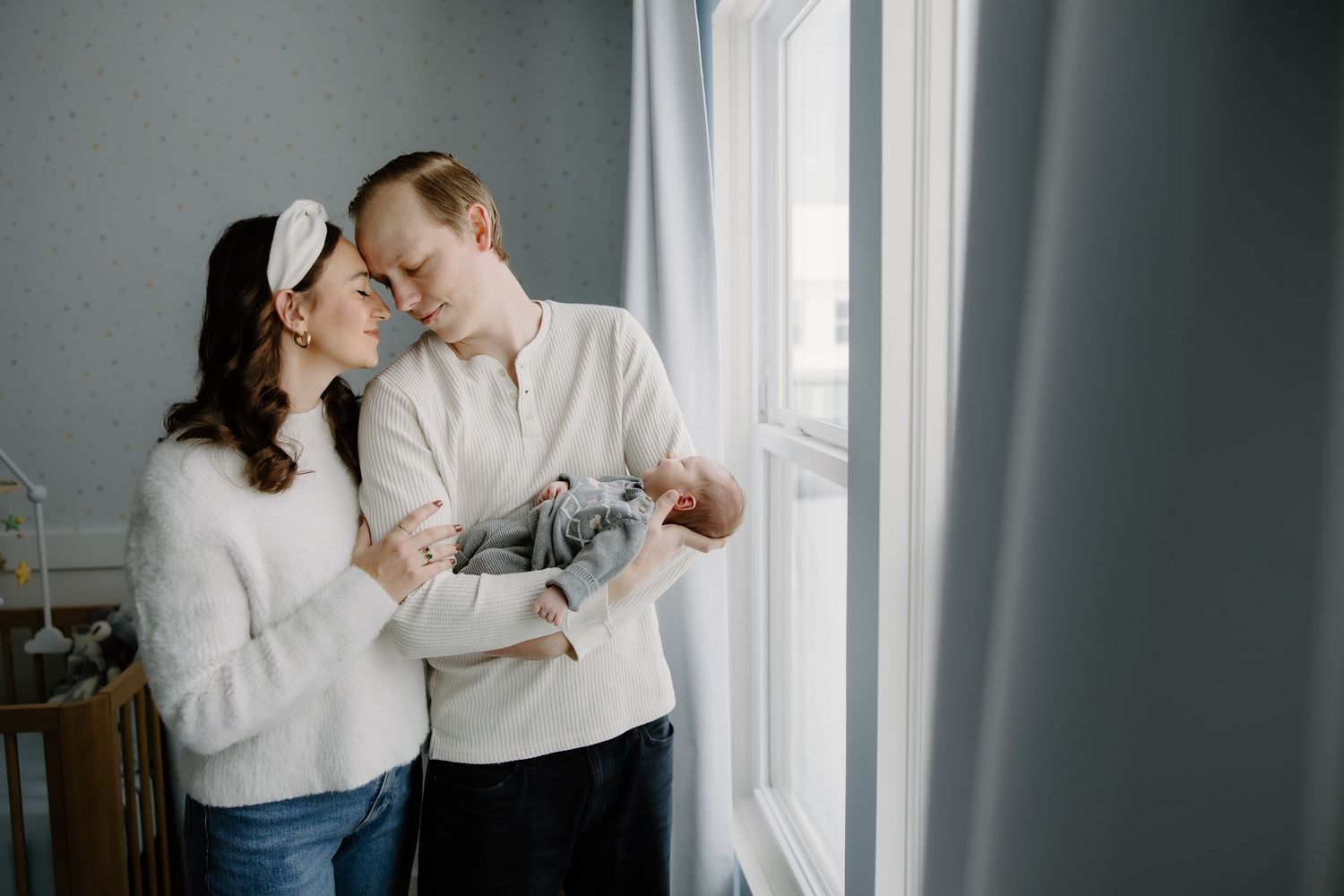 Intimate indoor portrait session near a bright window with soft natural lighting.