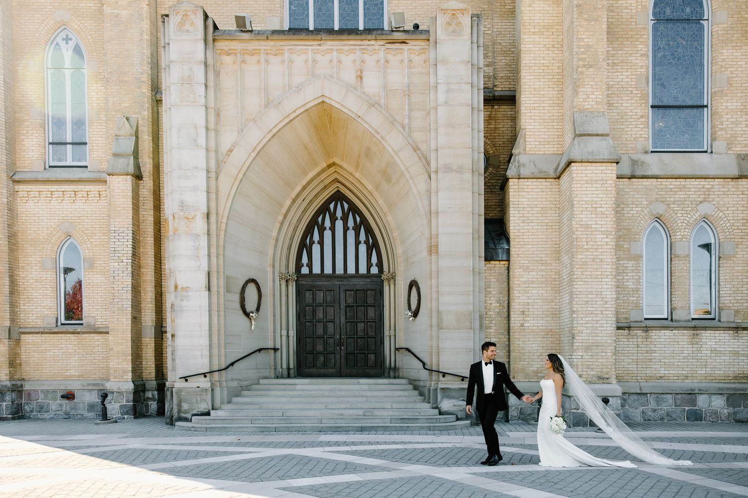 Elegant stone church facade with Gothic arches and architectural details on a bright sunny day.