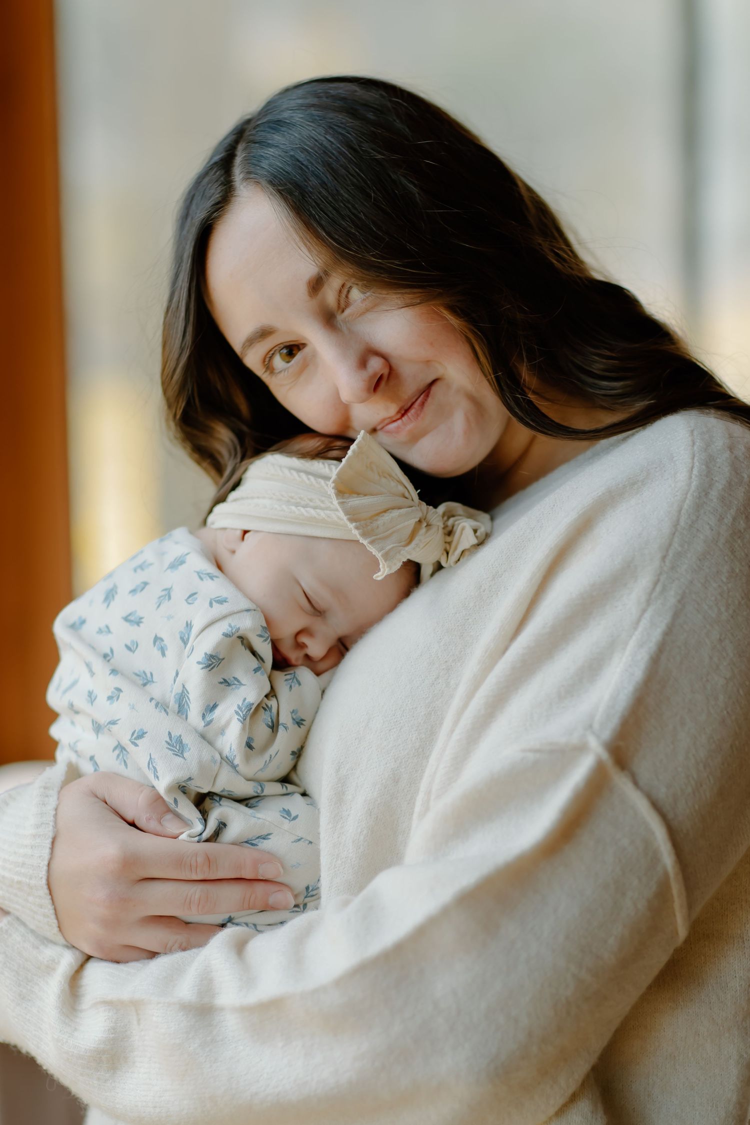 A peaceful moment captured as a parent cuddles their sleeping newborn baby.