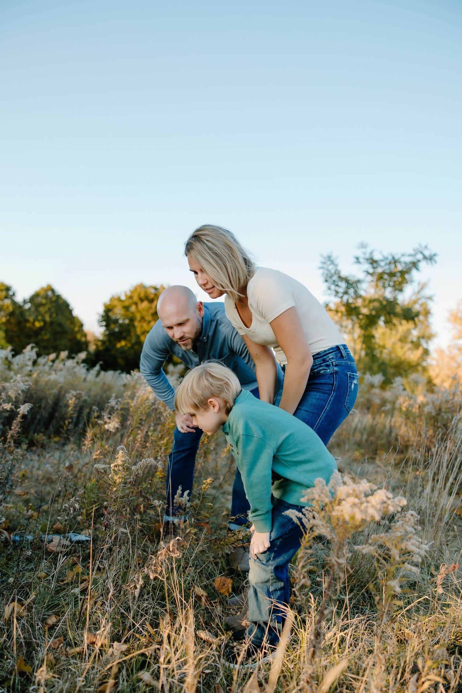 A group explores together in a sunlit meadow filled with tall golden grass during sunset.
