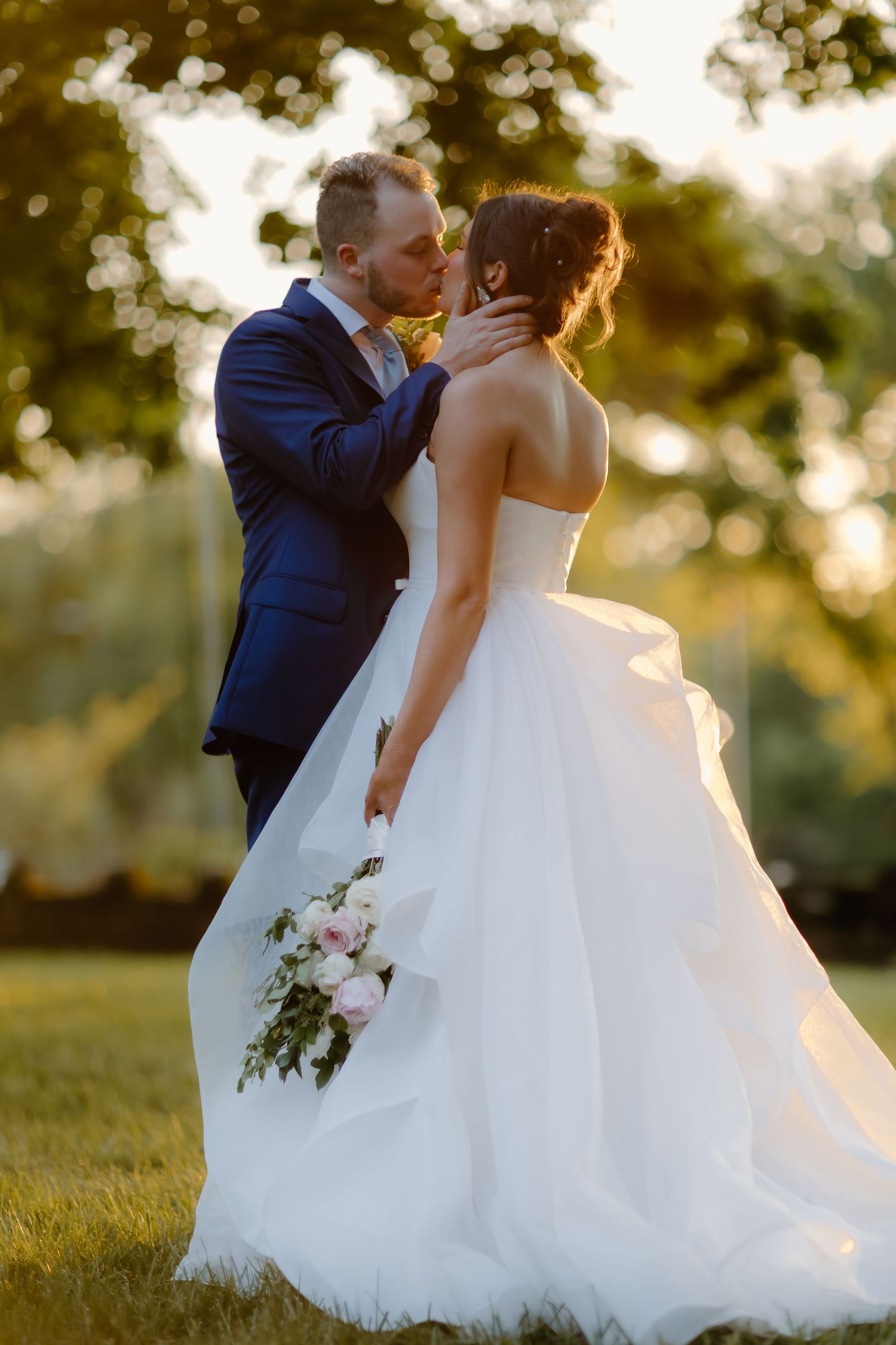 Romantic sunset wedding portrait with flowing white ballgown dress.