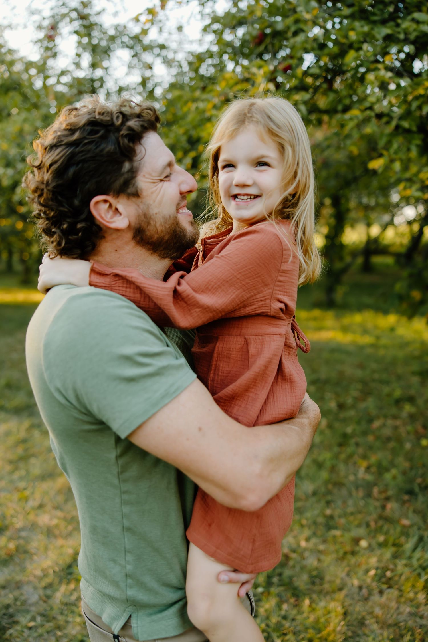 Loving embrace between parent and child in a sunny outdoor setting.