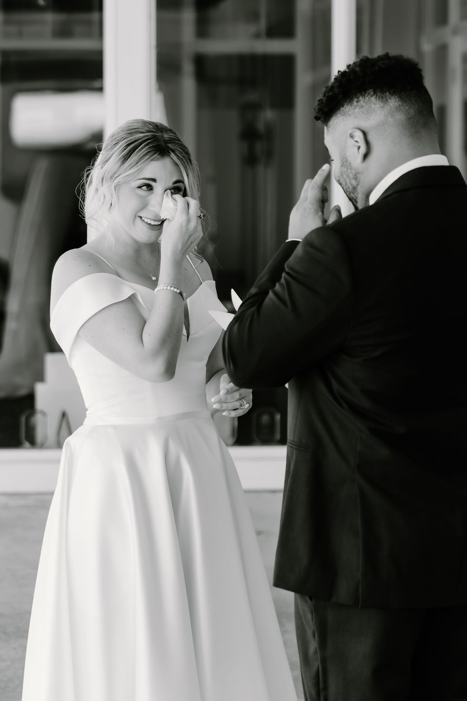 A wedding couple shares an intimate first look moment in black and white photography.