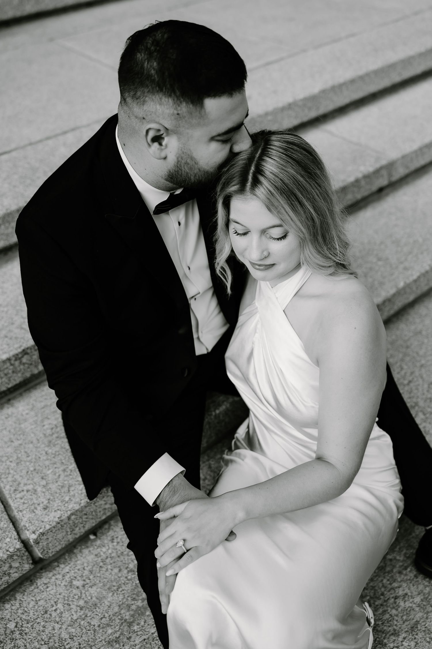 Artistic black and white wedding portraits on architectural steps.