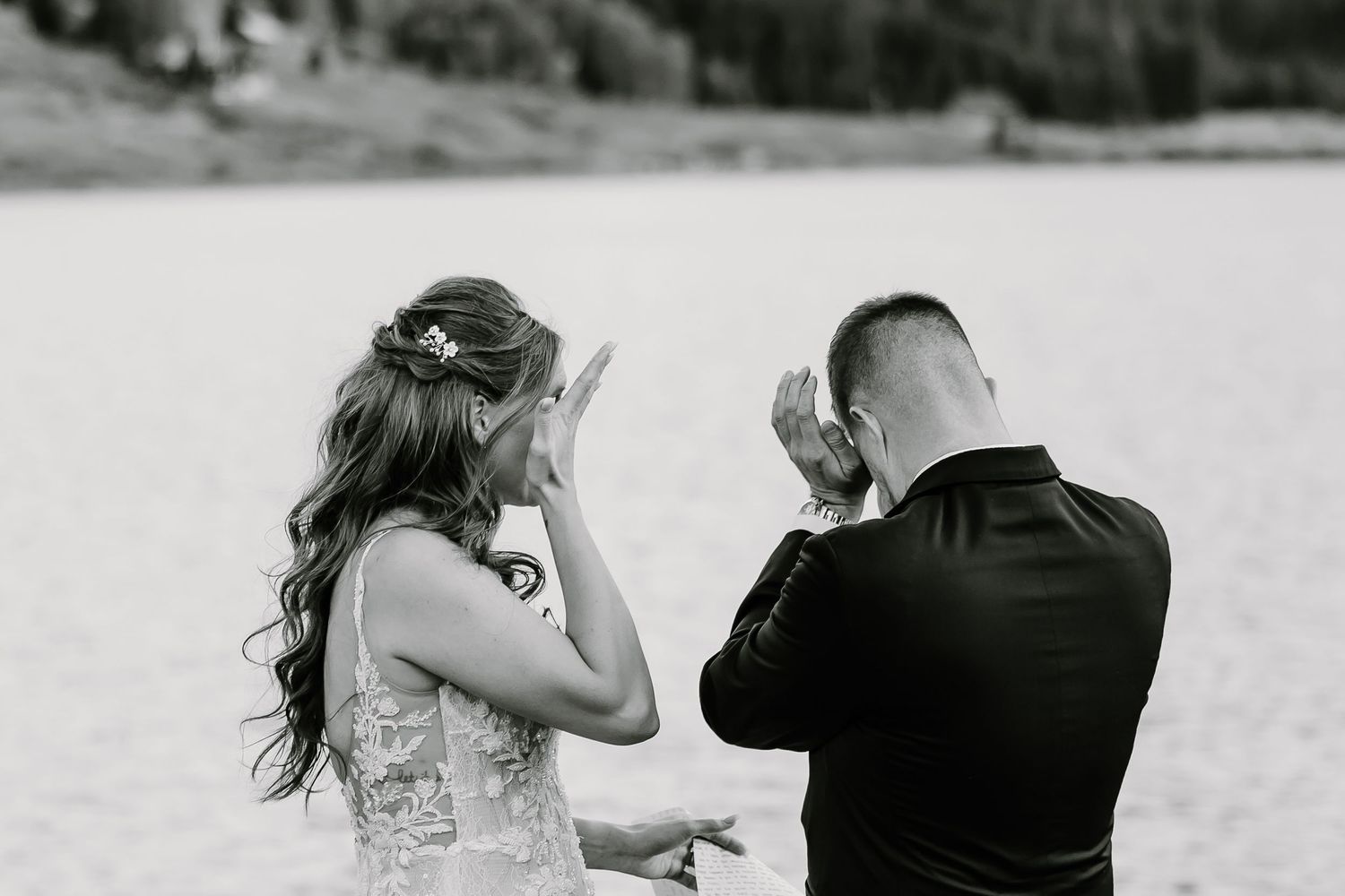 Candid emotional reactions during wedding vow exchange against mountain landscape.
