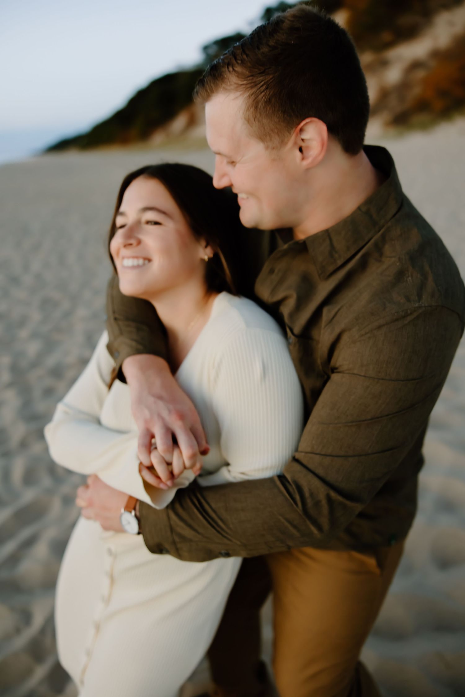 Intimate couple portrait session on beach during golden hour.