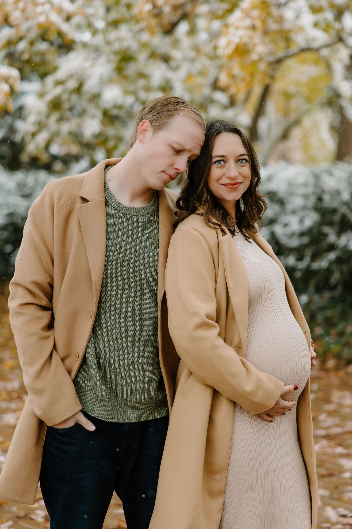 Romantic winter maternity photos with couple in coordinating neutral tones.